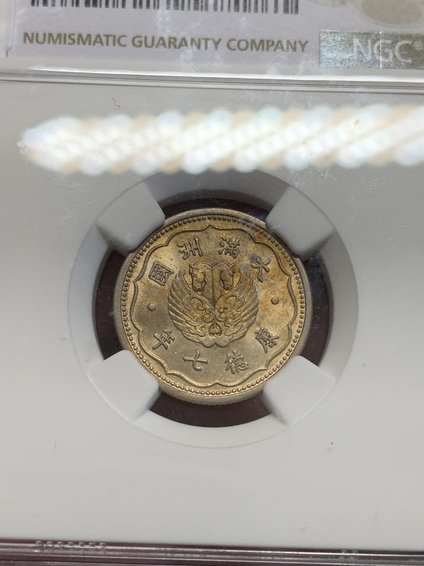 《竞宝斋》第193场-周日，周一 2场 (全场包邮) NGC-MS63 康德七年（1940）伪满洲国双头马壹角，镍币中很少见的金色包浆，状态难得。转光流畅，金彩诱人。