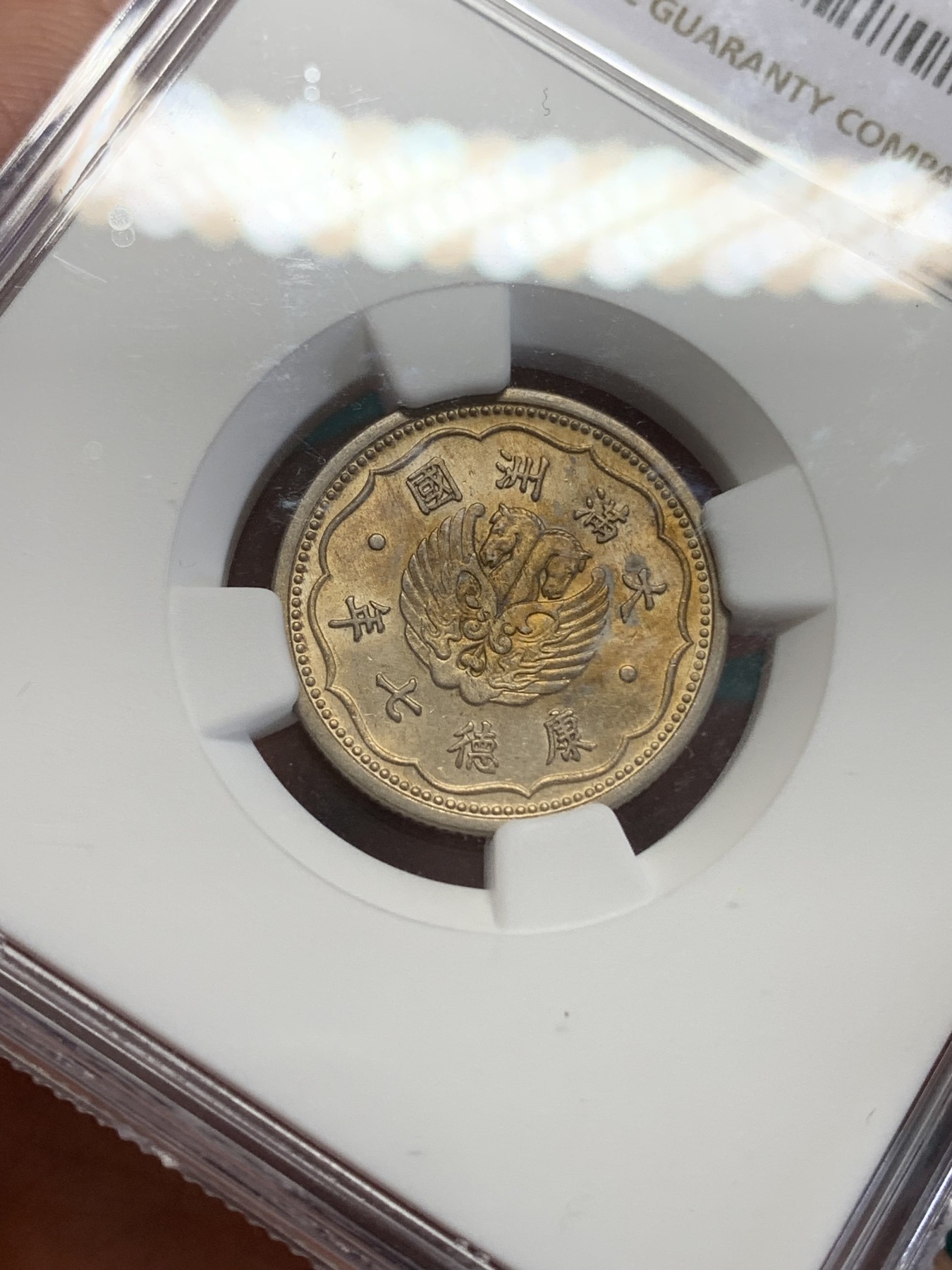 《竞宝斋》第193场-周日，周一 2场 (全场包邮) NGC-MS63 康德七年（1940）伪满洲国双头马壹角，镍币中很少见的金色包浆，状态难得。转光流畅，金彩诱人。