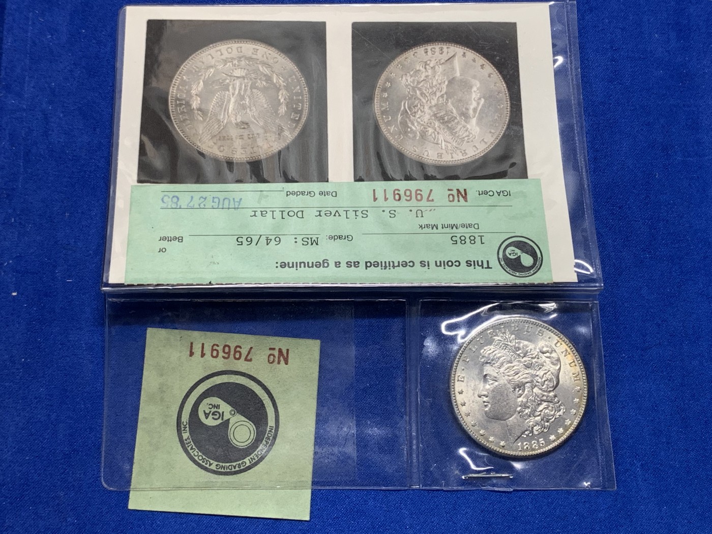 《竞宝斋》第194场-周日，周一 2场 (全场包邮) 早期ICG，80年代评级 MS64/65 美国1885年摩根大银币。ICG早期评级的产物，1985年8月27日评级。当时的评级规则是正反面分别评级，正面MS64，反面MS65，附柯达相纸印的币原始照片一张。