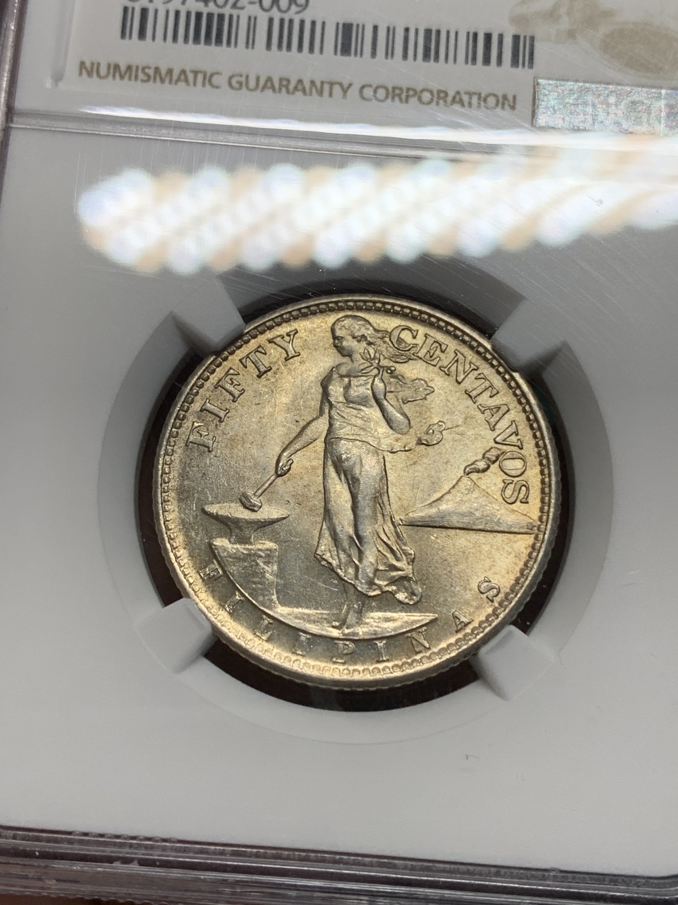 《竞宝斋》第194场-周日，周一 2场 (全场包邮) NGC-MS64 美属菲律宾1945年打铁女神50分银币，半圆大小，淡金色包浆，光度上佳。长发飘飘的行走女神
