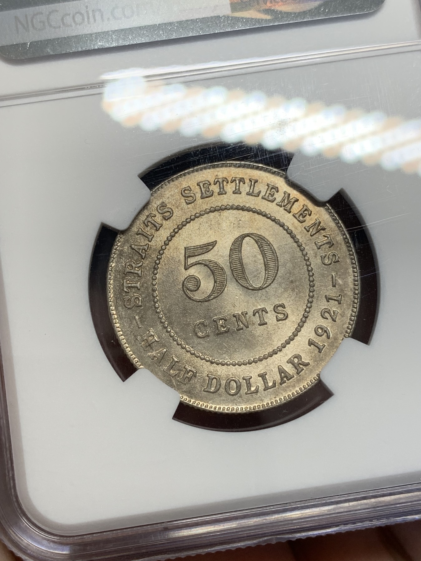 《竞宝斋》第201场-周日，周一 2场 (全场包邮) NGC-MS63 1921年英属海峡殖民地乔五50分银币，半圆大小。金彩包浆，车轮光。壹圆同分已经三四千起步，半圆仍具潜力。