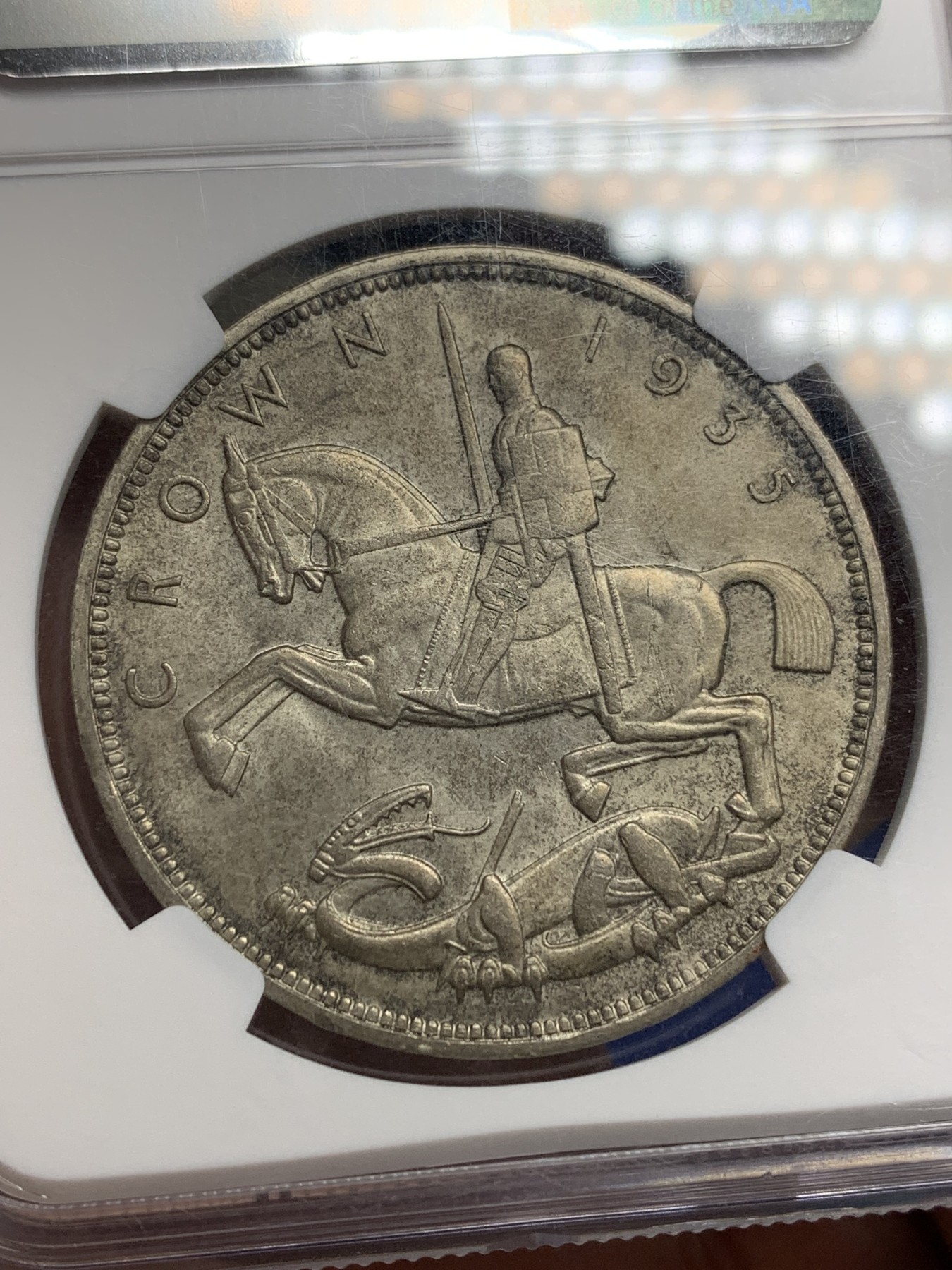 《竞宝斋》第205场-周日，周一 2场 (全场包邮) NGC-MS63 英国1935年乔治五世克朗大银币 黑包浆 底板带银霜光，背面马剑细节清晰可见，带边铭刻字纪年版