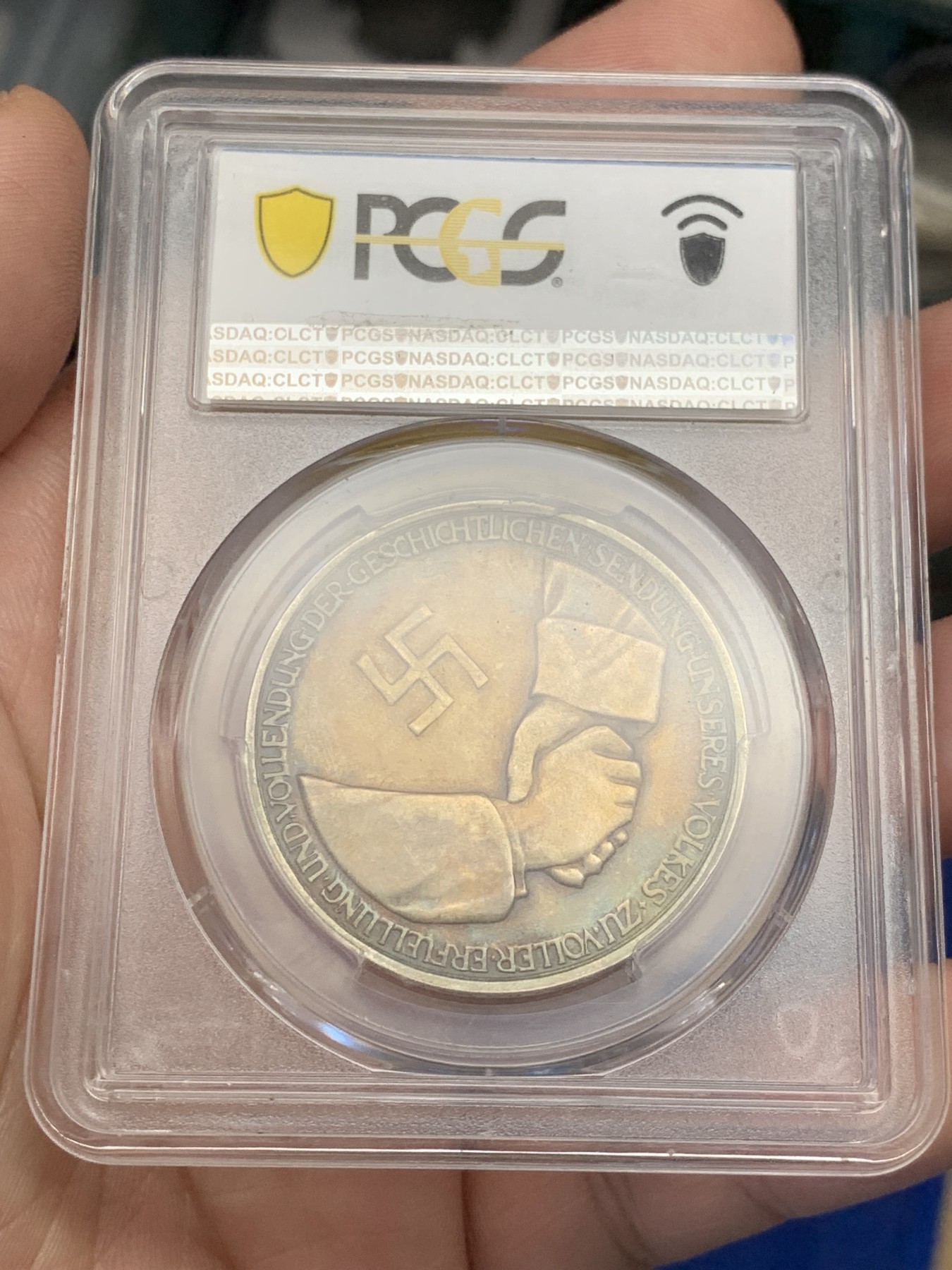 《竞宝斋》第207场-周日，周一 2场 (全场包邮) PCGS-SP62 德国1934年兴登堡交接纪念银章 炫彩包浆 带特殊标志 人物表面黑线为盒子小裂纹，多角度可见