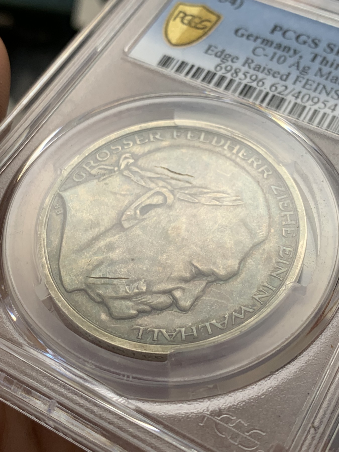 《竞宝斋》第207场-周日，周一 2场 (全场包邮) PCGS-SP62 德国1934年兴登堡交接纪念银章 炫彩包浆 带特殊标志 人物表面黑线为盒子小裂纹，多角度可见