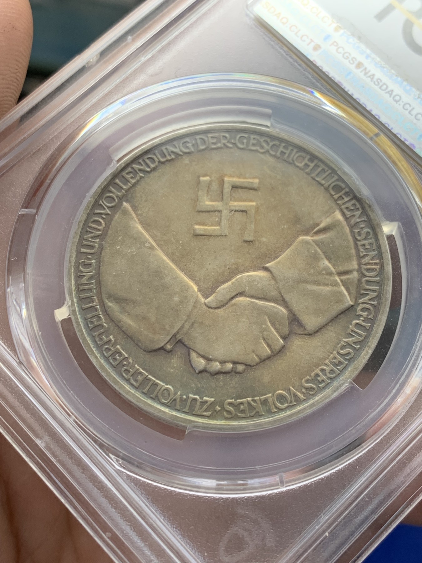 《竞宝斋》第207场-周日，周一 2场 (全场包邮) PCGS-SP62 德国1934年兴登堡交接纪念银章 炫彩包浆 带特殊标志 人物表面黑线为盒子小裂纹，多角度可见