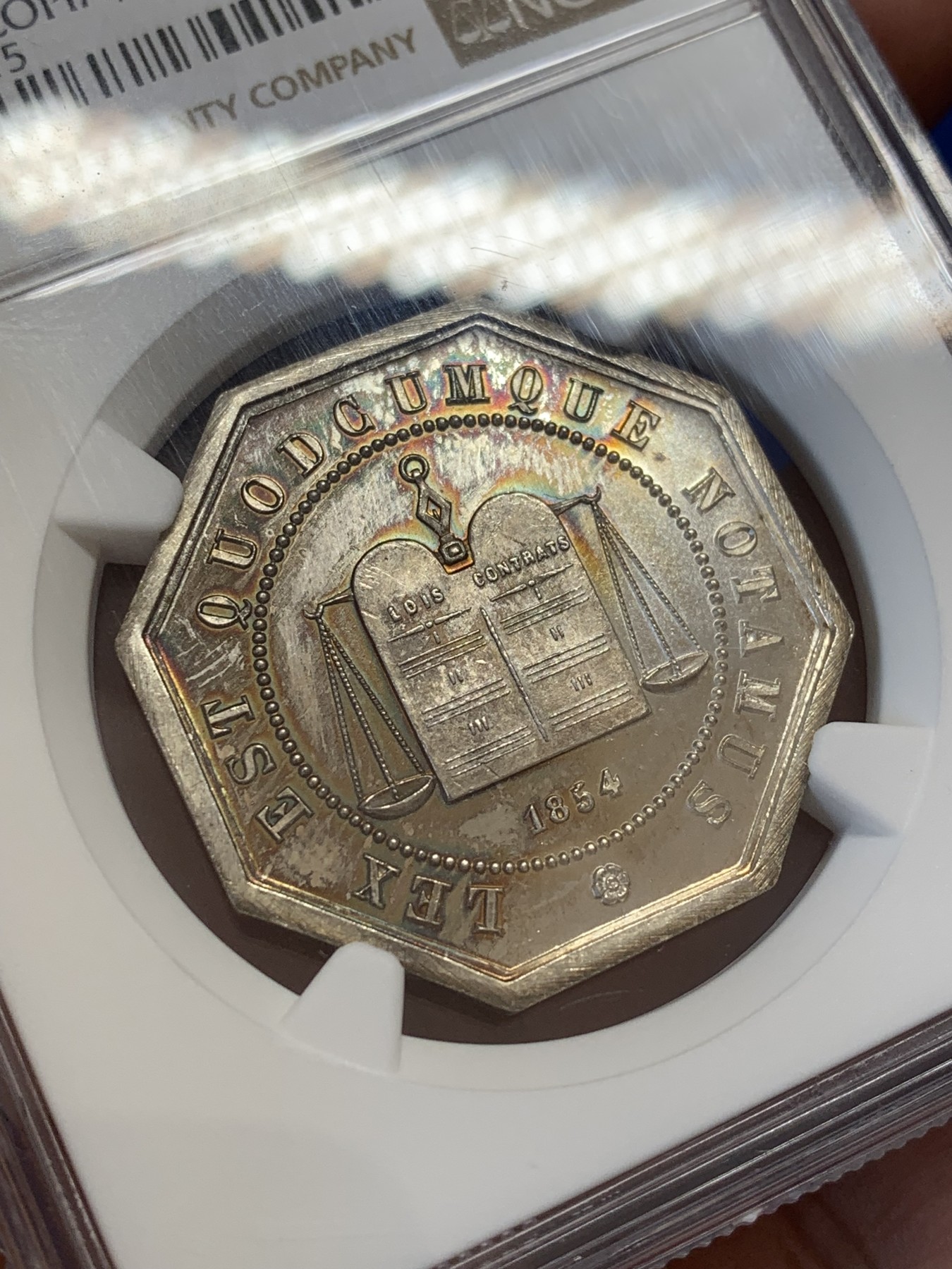 《竞宝斋》第207场-周日，周一 2场 (全场包邮) NGC-MS65 法国1854亚眠公证处天平八角银质八角代币，正面为典法后面的天平秤下方年份，背面为花枝环绕的铭文，顶级高分，丰饶角+ARGENT银标边铭，非常漂亮且少见的百年老银章原光五彩老包浆，状态极佳。