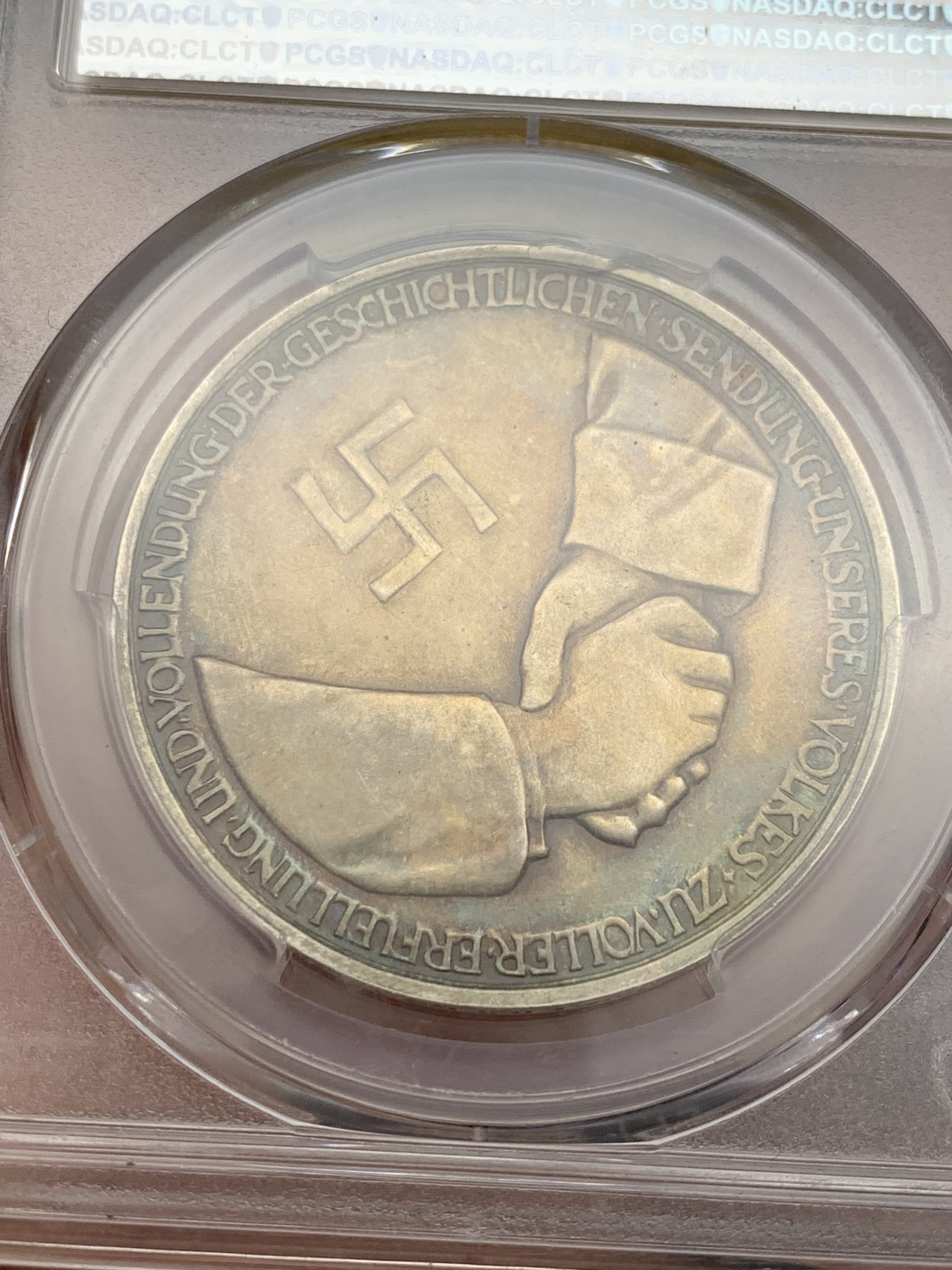 《竞宝斋》第207场-周日，周一 2场 (全场包邮) PCGS-SP62 德国1934年兴登堡交接纪念银章 炫彩包浆 带特殊标志 人物表面黑线为盒子小裂纹，多角度可见