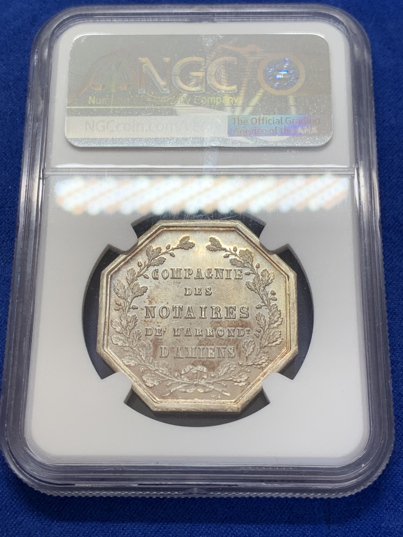 《竞宝斋》第207场-周日，周一 2场 (全场包邮) NGC-MS65 法国1854亚眠公证处天平八角银质八角代币，正面为典法后面的天平秤下方年份，背面为花枝环绕的铭文，顶级高分，丰饶角+ARGENT银标边铭，非常漂亮且少见的百年老银章原光五彩老包浆，状态极佳。