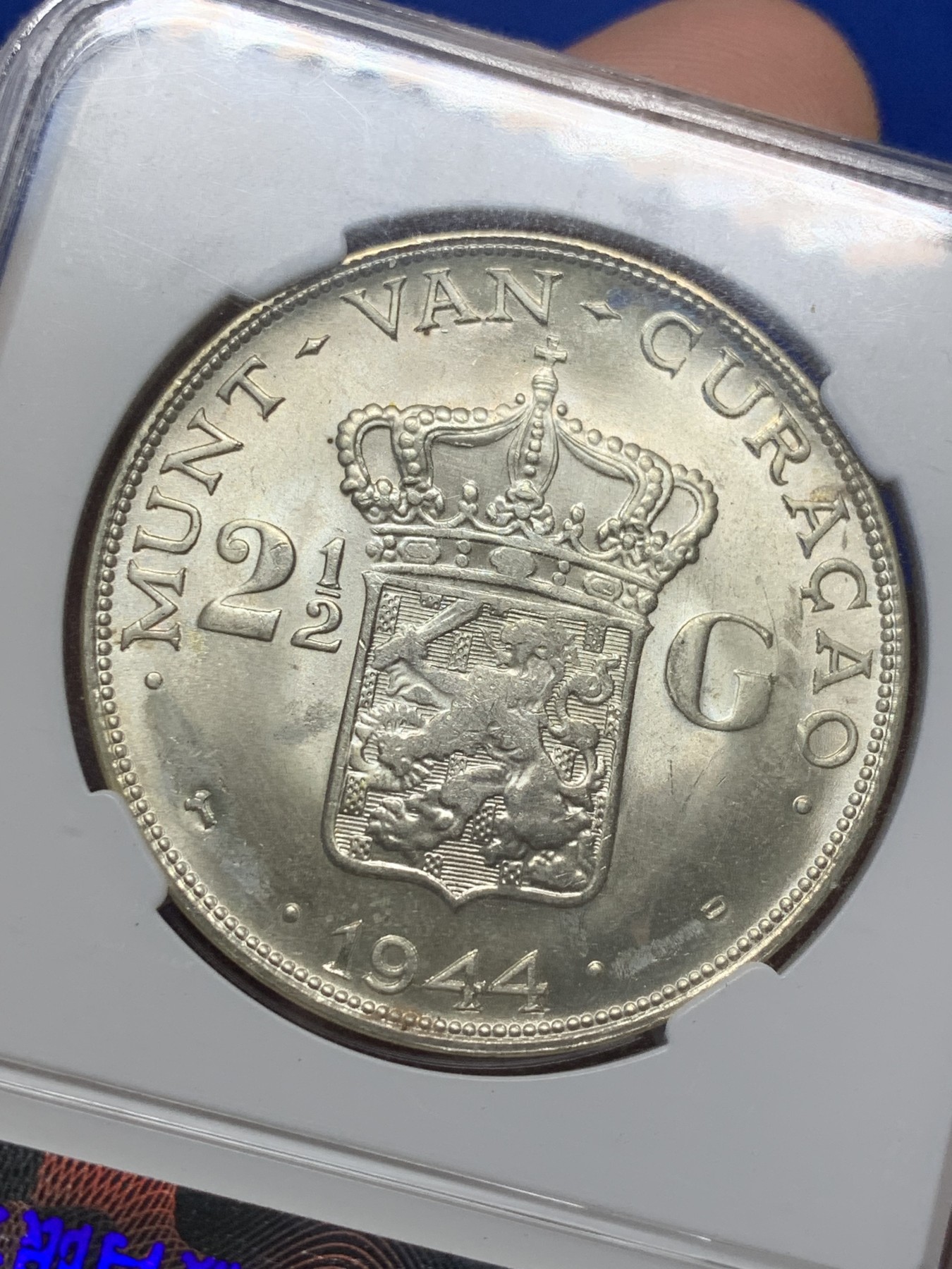 《竞宝斋》第208场-周日，周一 2场 (全场包邮) 保粹评级MS65，荷属库拉索1944年威廉明娜2.5盾大银币，保粹早期老盒严评，状态极佳，高分精品