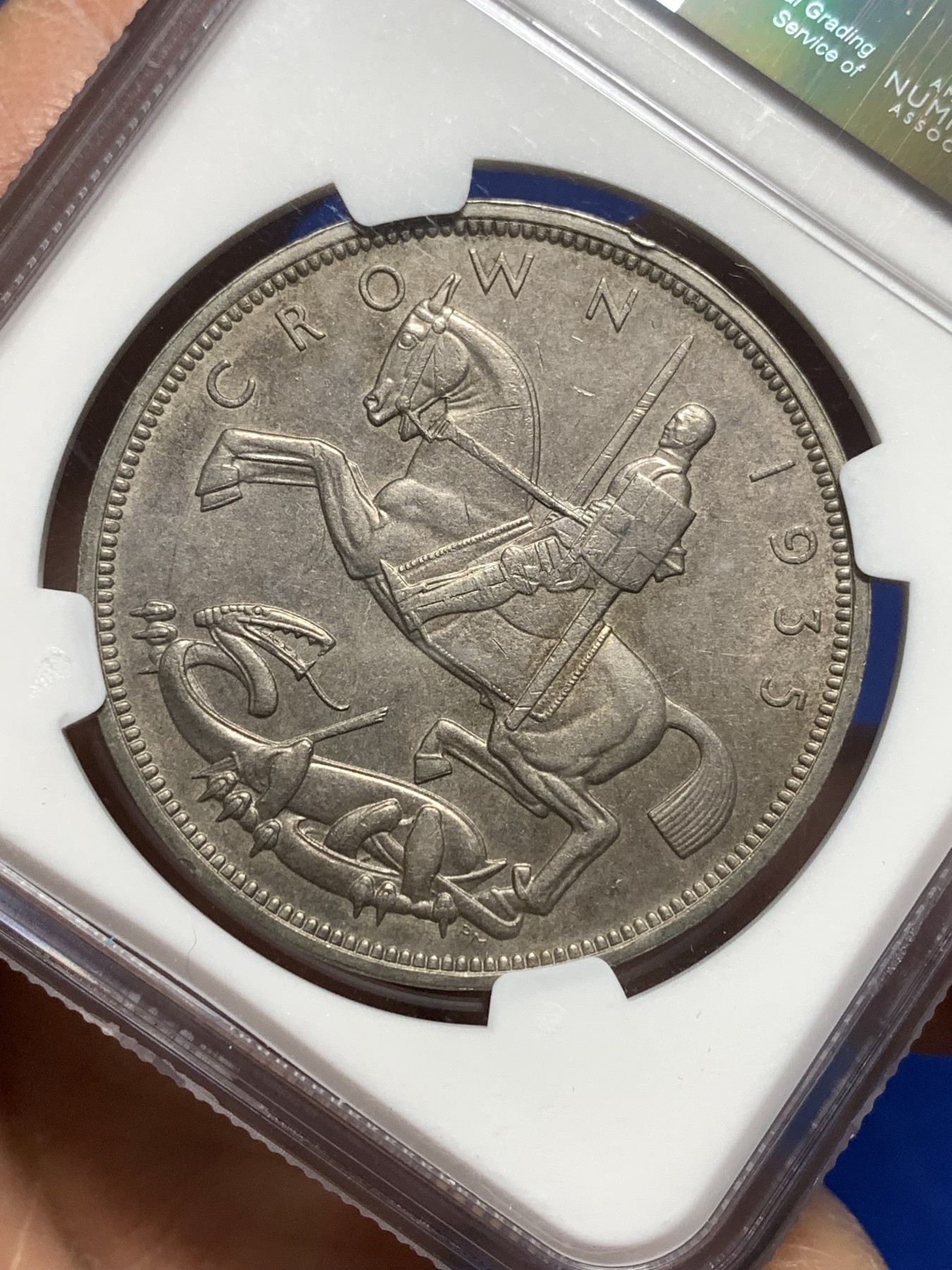 《竞宝斋》第215场-周日，周一 2场 (全场包邮) NGC-MS63 英国1935年乔治五世1克朗木马剑大银币，图案精美，英系热门品种之一，玩家配版必备。原汁原味老包浆，状态极佳，非常漂亮。