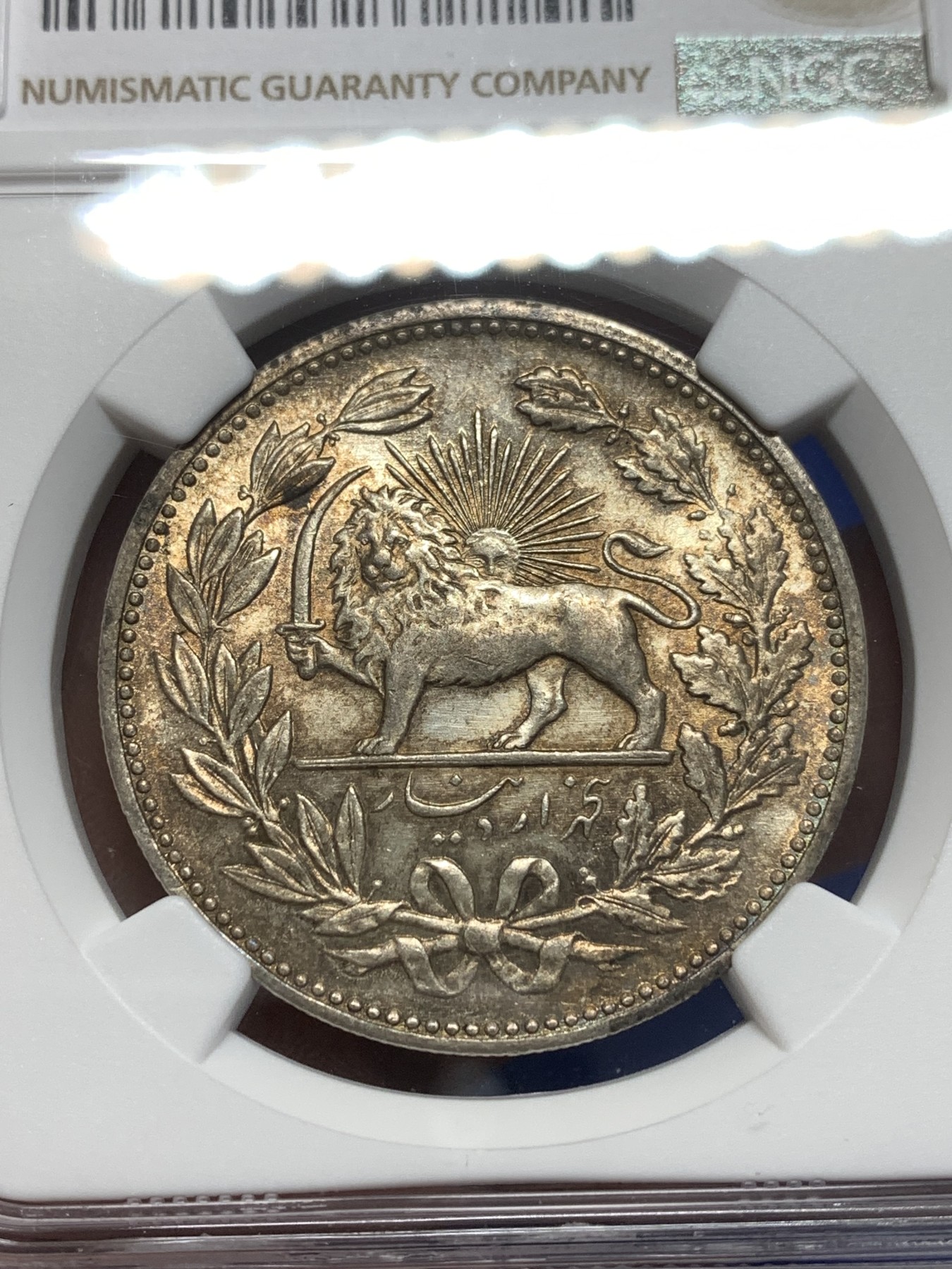 《竞宝斋》第215场-周日，周一 2场 (全场包邮) NGC AUD 1902伊朗5000第纳尔大银币，奶油黄，拿刀雄狮背后太阳清晰，包浆漂亮，整体感觉干净。