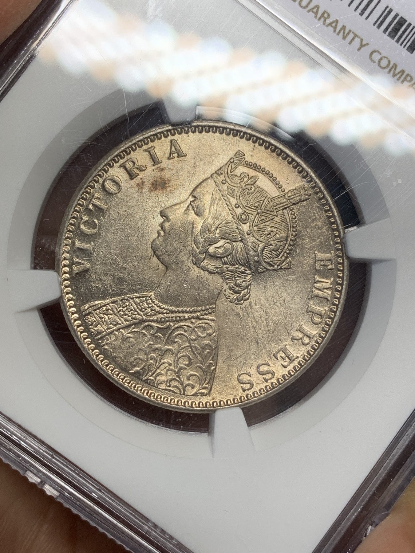 《竞宝斋》第216场-周日，周一 2场 (全场包邮) NGC MS62 印度1900年维多利亚1卢比银币 底板转光好 淡彩包浆