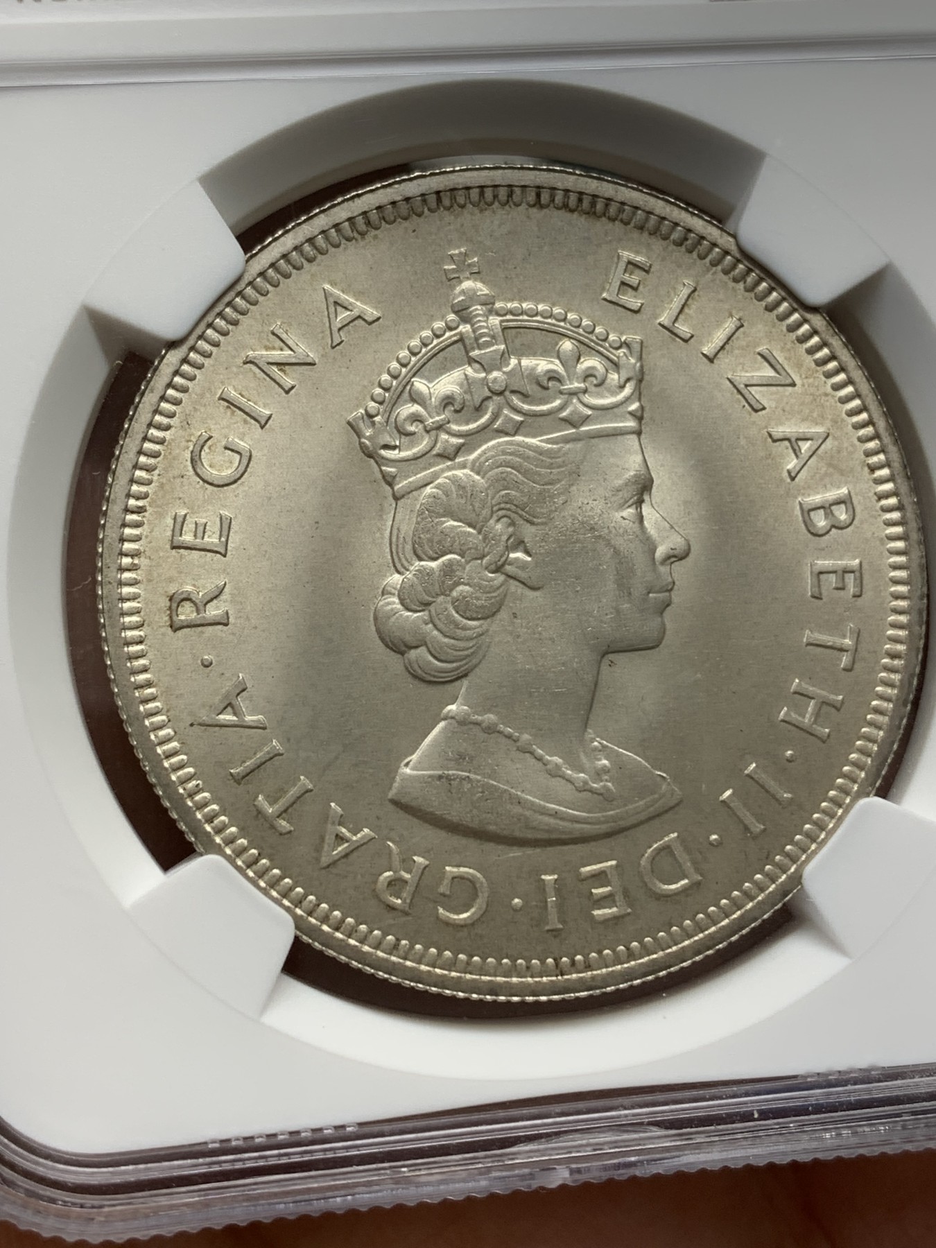 《竞宝斋》第218场-周日，周一 2场 (全场包邮) NGC-MS64 英属百慕大群岛1959年伊丽莎白二世1克朗银币，直径38mm，重28.28克，925银，发行量100010枚。自治的英国海外领地独立发行的首枚钱币。车轮转光，非常漂亮。