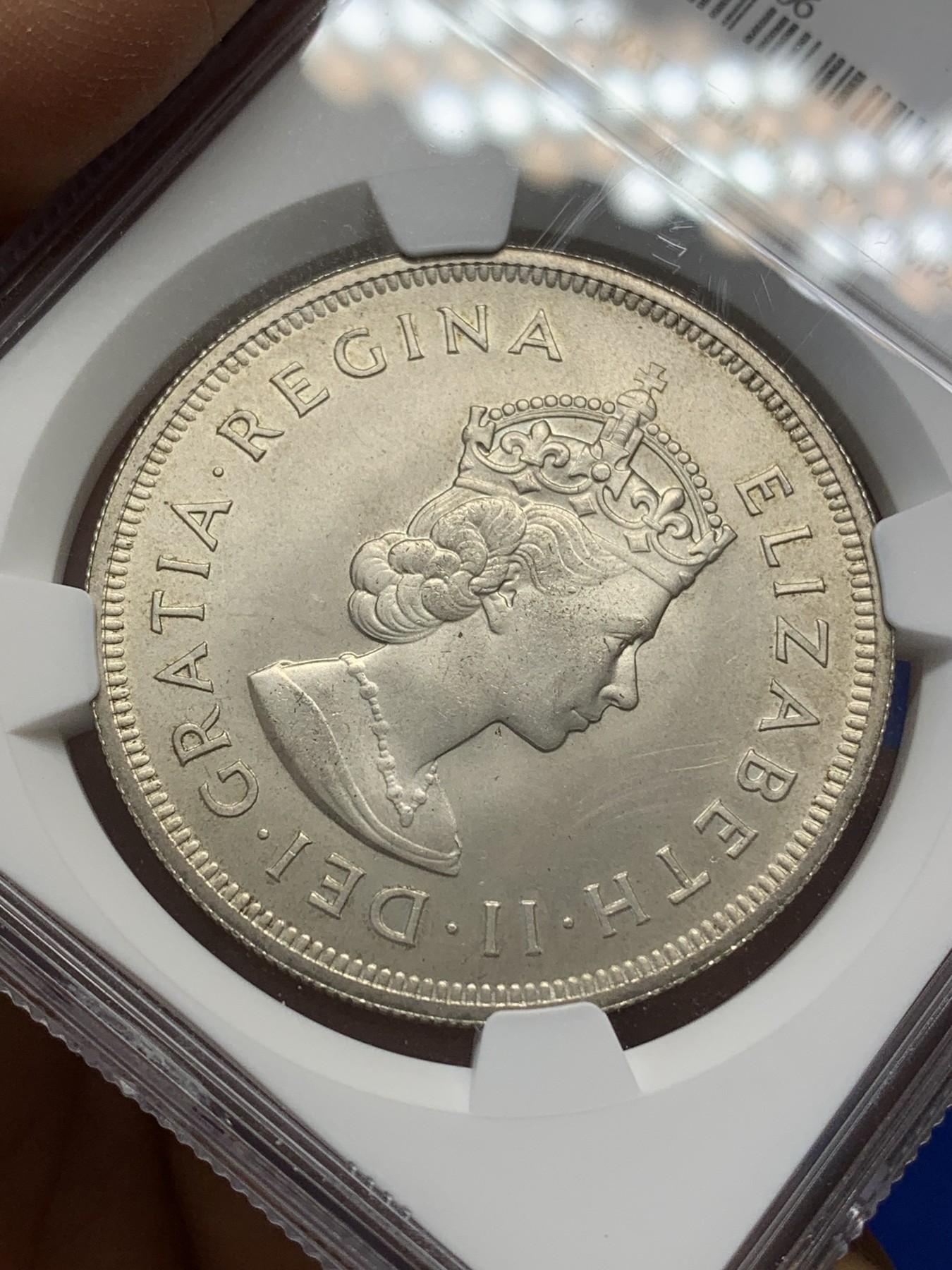 《竞宝斋》第218场-周日，周一 2场 (全场包邮) NGC-MS64 英属百慕大群岛1959年伊丽莎白二世1克朗银币，直径38mm，重28.28克，925银，发行量100010枚。自治的英国海外领地独立发行的首枚钱币。车轮转光，非常漂亮。