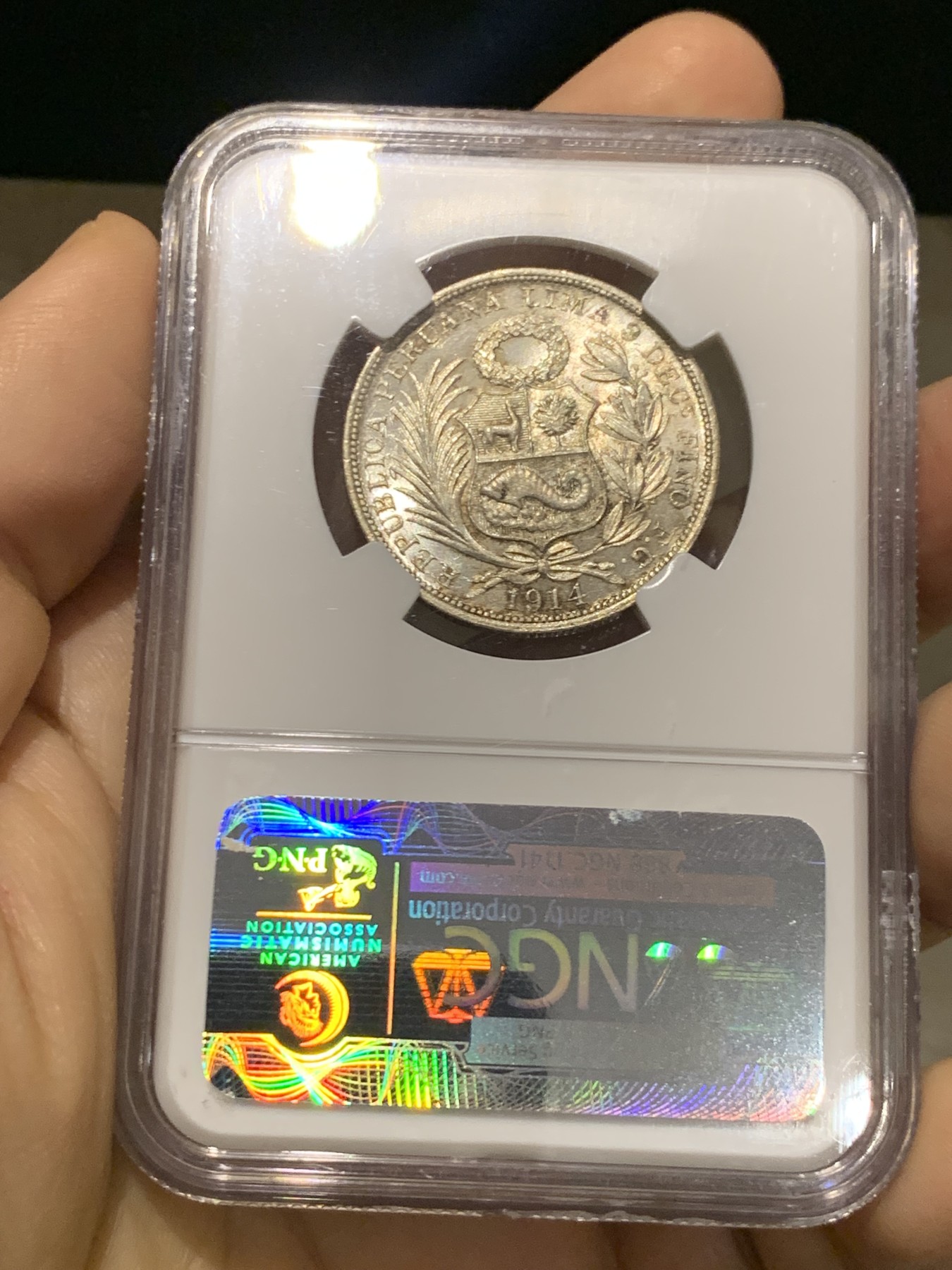 《竞宝斋》第219场-周日，周一 2场 (全场包邮) NGC-MS63 1914年秘鲁1/2索尔坐人女神银币，半圆大小，经典坐人设计。霜银暴光，底板有镜面感。老盒好品质，光度不输64。