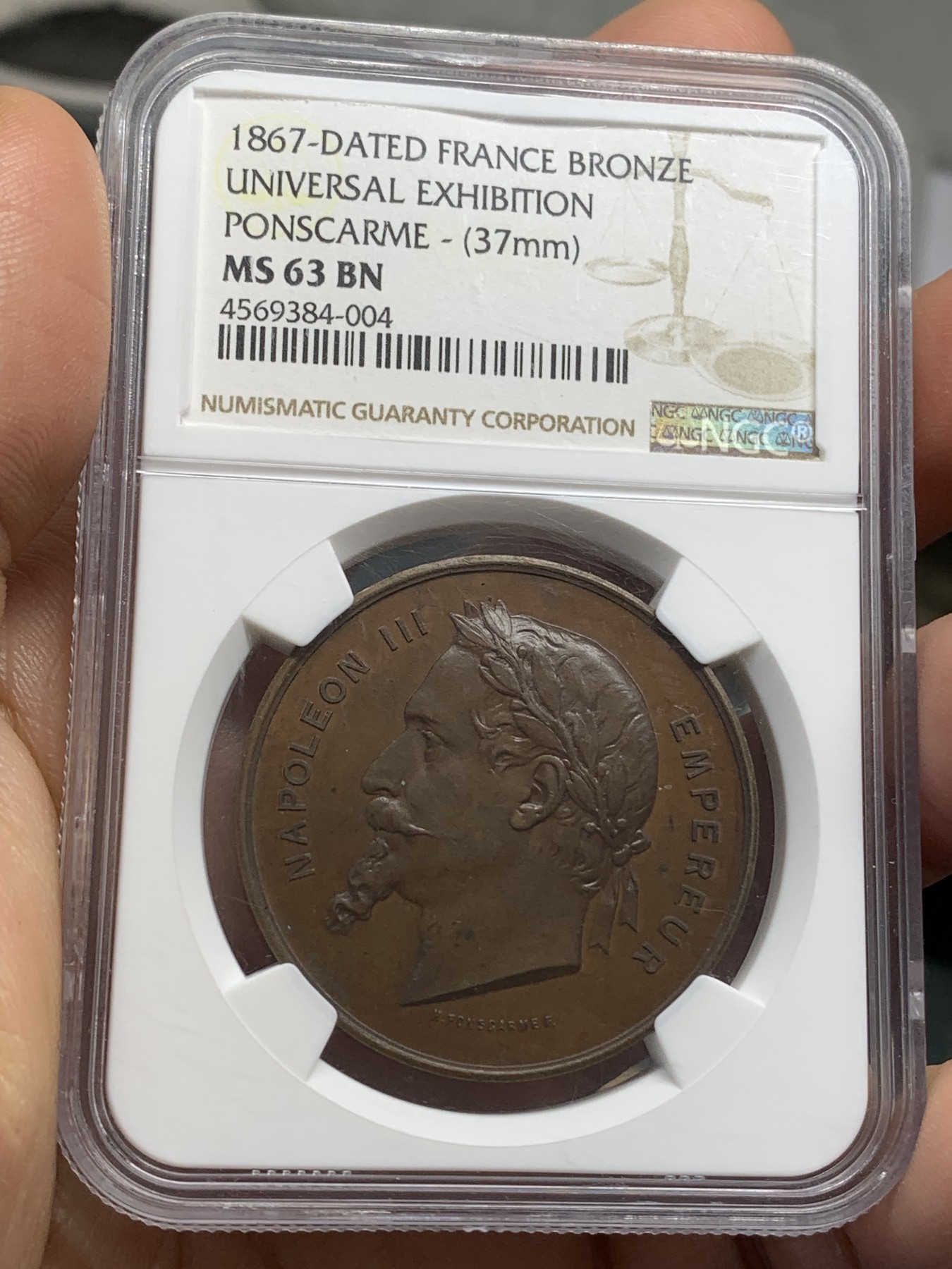 《竞宝斋》第219场-周日，周一 2场 (全场包邮) NGC-MS63 法国1867年巴黎世博会纪念大铜章，经典的拿破仑三世桂冠头像。背面天使轻盈飞舞，衣袂轻扬，造型生动。红棕色巧克力包浆，状态极佳。