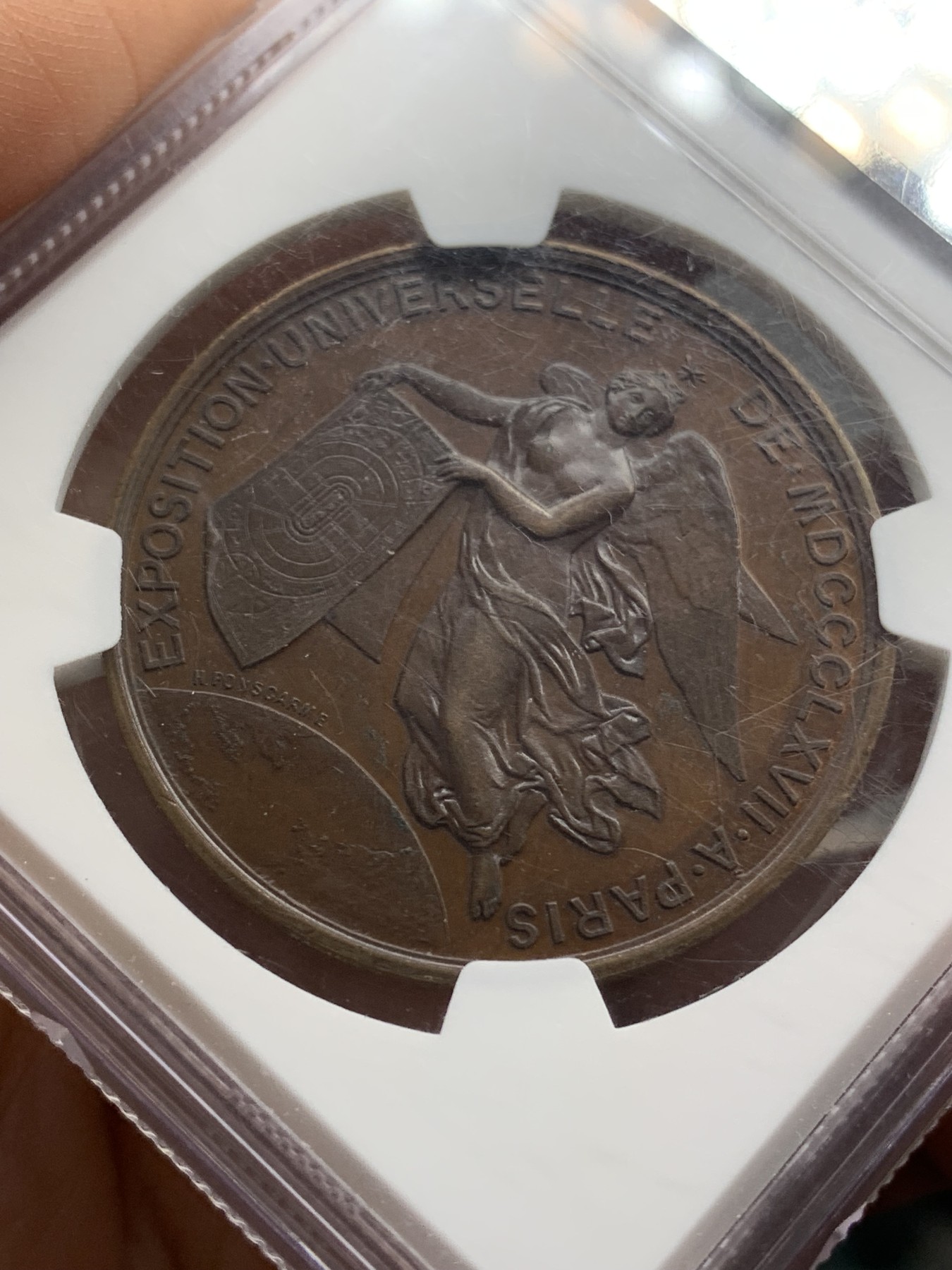 《竞宝斋》第219场-周日，周一 2场 (全场包邮) NGC-MS63 法国1867年巴黎世博会纪念大铜章，经典的拿破仑三世桂冠头像。背面天使轻盈飞舞，衣袂轻扬，造型生动。红棕色巧克力包浆，状态极佳。