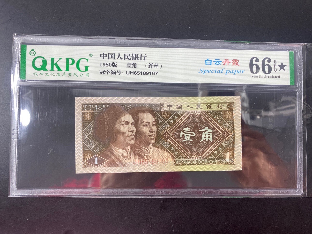 一线荧光币第330期拍场 钱坤评级8001UH特强白云丹霞，UH65189167，全程无四，评级币单张。特点一：“白云”为纸张白色荧光（偶尔伴有纤丝纤云特点），和普通8001相比区别明显，整刀5种荧光效果中包含普通黄金甲。特点二：“丹霞”为票面正面的红蓝色网格荧光，加上纸张的白色荧光形成了美妙的“白云丹霞”效果。