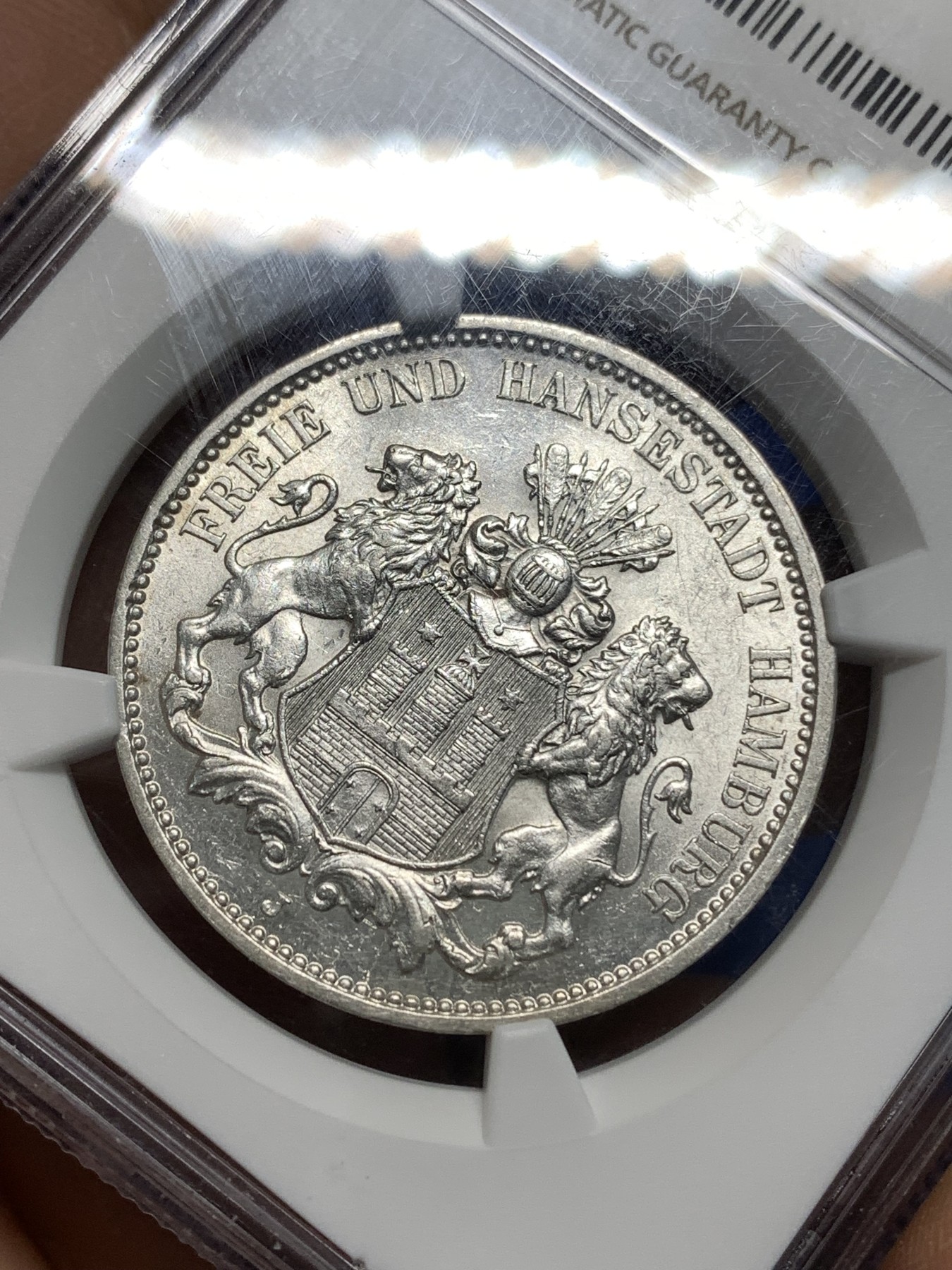 《竞宝斋》第221场-周日，周一 2场 (全场包邮) NGC-AU58 德国1911年汉堡自由市3马克银币，图案精美，纹饰优雅，历史价值浓郁。原汁原味老包浆，低评，状态绝对不输MS品质，非常漂亮，AU58超高的性价比，获得更高评分数量才95枚。