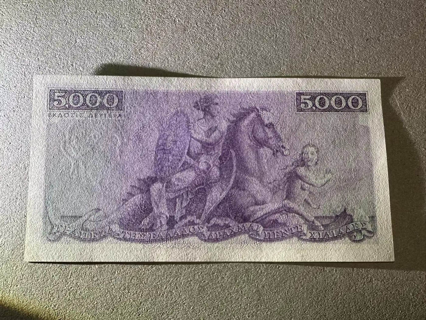 【Blue Auction】✨世界纸币精拍第402期【精】 希腊  1945年5000德拉科马  UNC-  紫色版 雕刻非常精美 正面圣母 背面描述：在特洛伊城，海洋女神忒提斯骑着海马，将赫菲斯托斯锻造的盾牌带给她的儿子阿喀琉斯