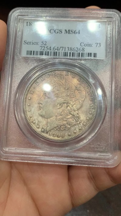 《竞宝斋》第222场-周日，周一 2场 (全场包邮) PCGS-MS64 美国1898年摩根银币O版，原汁原味五彩老包浆，包浆醇厚，卷首币，状态一流。P盒早期小白盒，发行量和市场上较少年份的版本，铸币数量444万枚。
