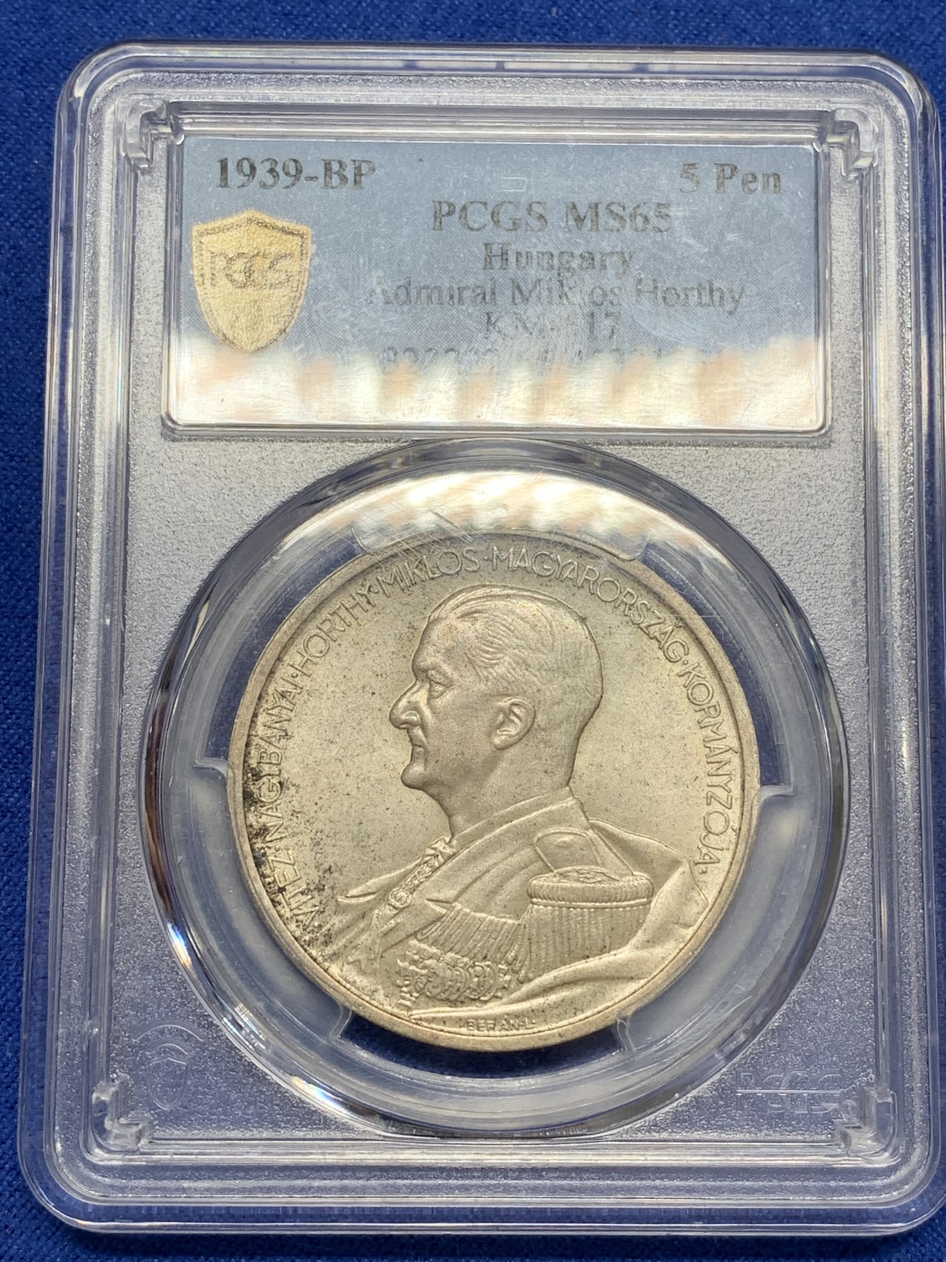 《竞宝斋》第223场-周日，周一 2场 (全场包邮) PCGS-MS65 匈牙利1939年海军上将霍尔蒂5潘戈银币，原厂初铸，难得高分。此枚银币人物神态刻画炯炯有神，清晰精美的戎装和背面的匈牙利盾徽天使制作精良，更高评级数量才6枚。