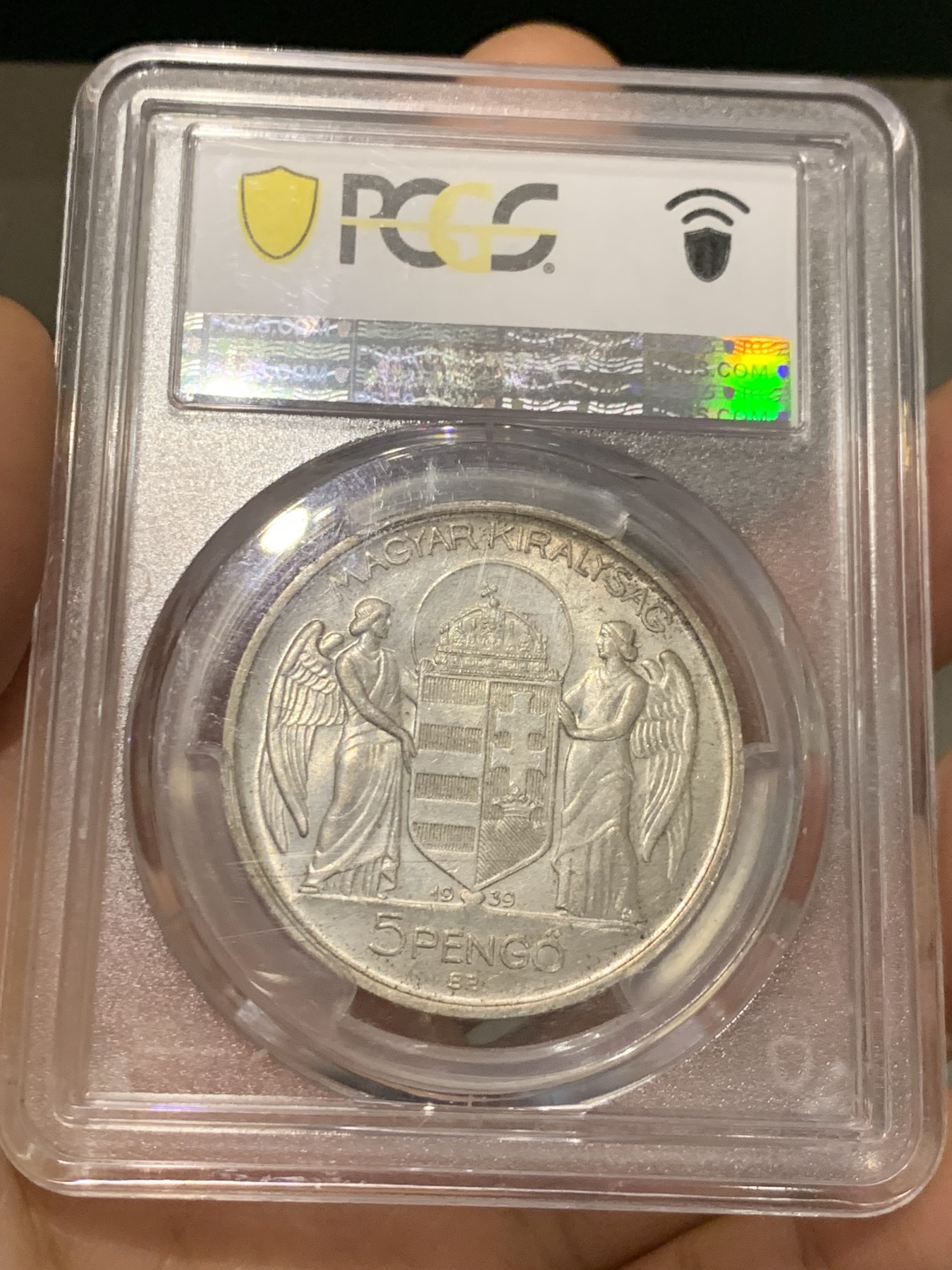 《竞宝斋》第223场-周日，周一 2场 (全场包邮) PCGS-MS65 匈牙利1939年海军上将霍尔蒂5潘戈银币，原厂初铸，难得高分。此枚银币人物神态刻画炯炯有神，清晰精美的戎装和背面的匈牙利盾徽天使制作精良，更高评级数量才6枚。