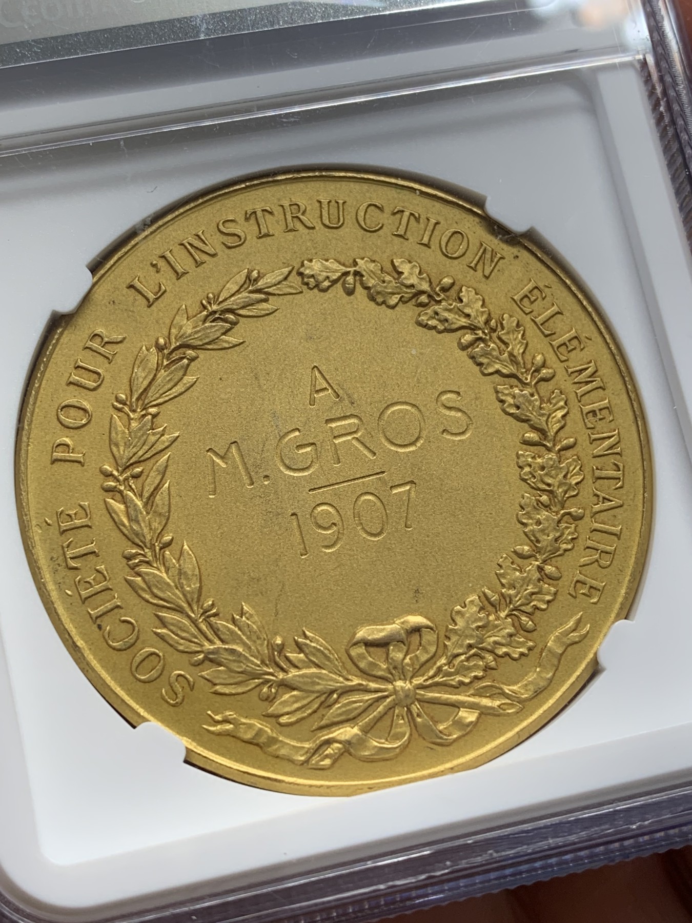 《竞宝斋》第223场-周日，周一 2场 (全场包邮) NGC-MS64 法国1907小天使教育学会铜质镀金奖章，四个小天使生动可爱，细节精美，惟妙惟肖。此版多见铜章，镀金版非常少见，镀层状态完美。
