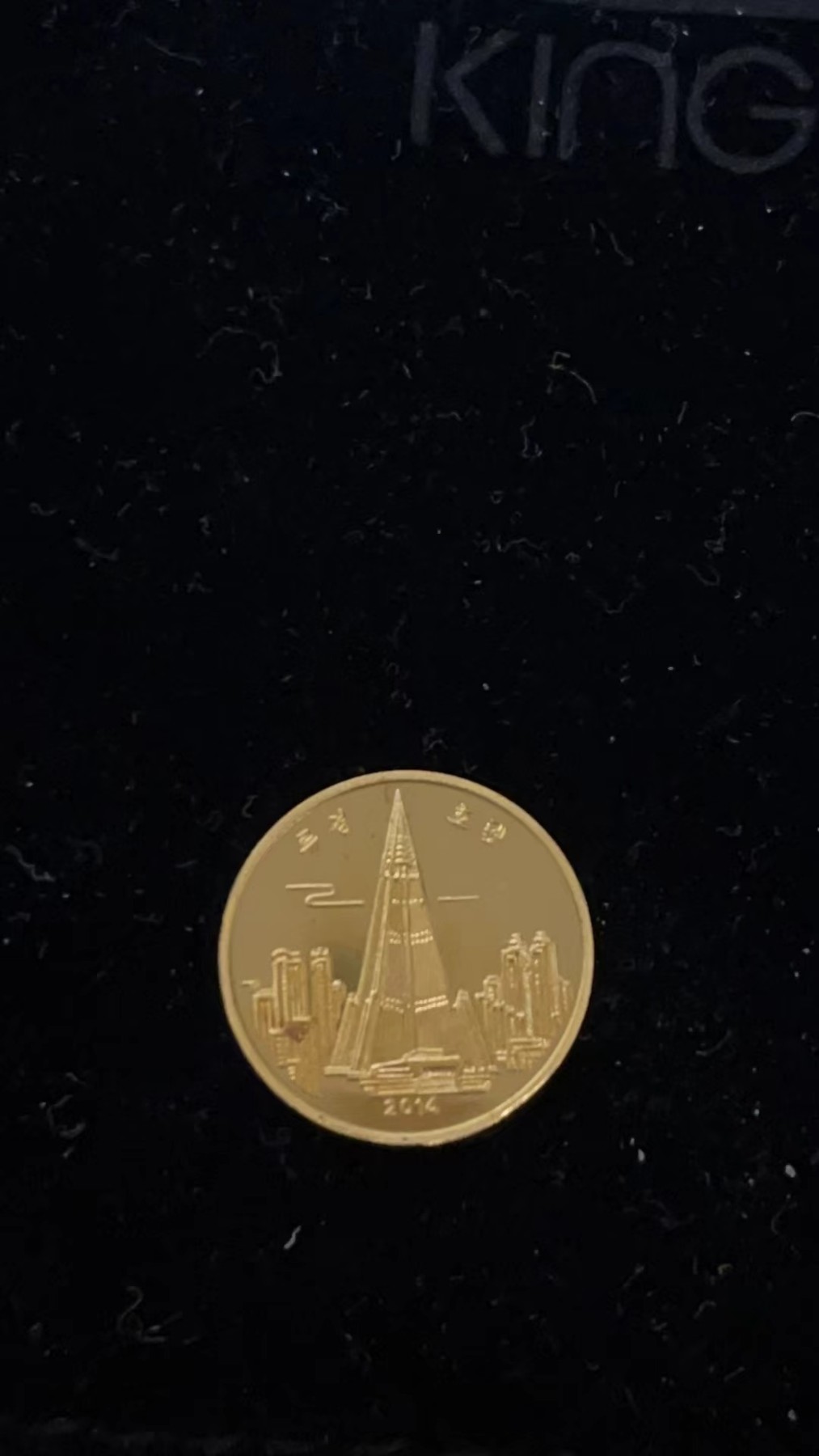 254.【鲸贝乐淘★两拍包邮】弟子规·第“父母教，须敬听， 父母责，须顺承。”号拍卖 【朝鲜金币】柳京饭店 面值:4000朝鲜圆 年份：2014年 金属:999金 重量:1/10盎司 直径：16毫米 发行：199枚（证书编号170），略微有红斑如图