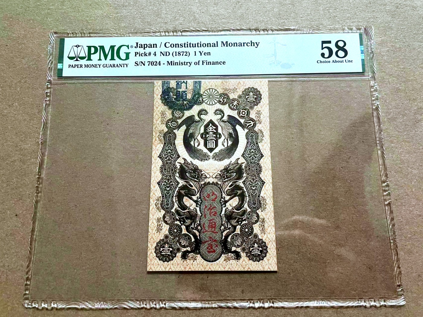 【Blue Auction】✨世界纸币精拍第409期【精】 【仅4枚64的更高分 唯一该分数 该枚状态非常佳】日本政府大藏省1872年明治通宝金壹圆 PMG58 打灯没有明显的折 该款竖版钞票是于德国法兰克福印制，送到日本加盖。纸币上方的两头长尾鸡，以及下方的两条对目而视的飞龙构成了瞩目震撼的外观，极具吸引力。克劳斯目录仅给到了XF品相参考价，文物级别，日本纸币玩家不可错过的精品。