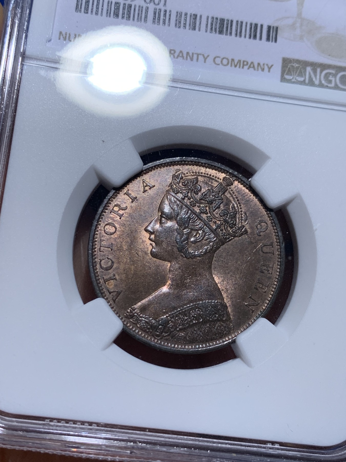 《竞宝斋》圣诞专辑  第一场  第227场 定制纪念章相赠 (全场顺丰包邮) NGC-MS63 香港1863年维多利亚女王香港一仙铜币。该品种流通币之首年，沿用了本土无神弗洛林的经典头像设计，背面是极具中国风味的文字排布，整币图案细腻文字工整，底板对光平滑，有一丝样币风范。以多点光源照射则光韵流畅盈满，辫子无常见弱打。巧克力色非常舒服，不输大多数64的状态，一步到位的东西。