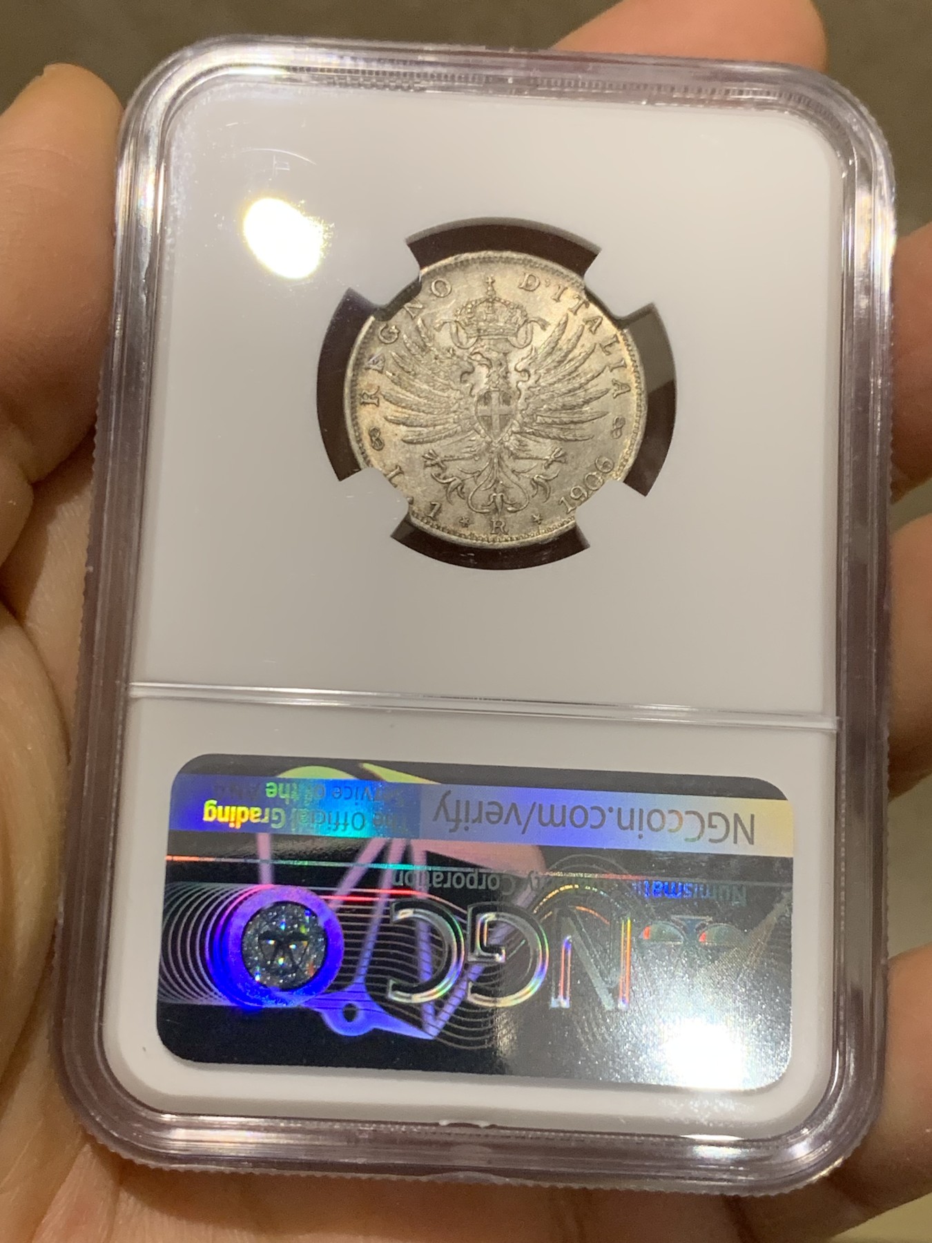 《竞宝斋》圣诞专辑  第一场  第227场 定制纪念章相赠 (全场顺丰包邮) NGC-MS64 意大利 1906年 鹰徽1里拉银币 灰黑色淡包浆 转光感与底板完美，难得好状态