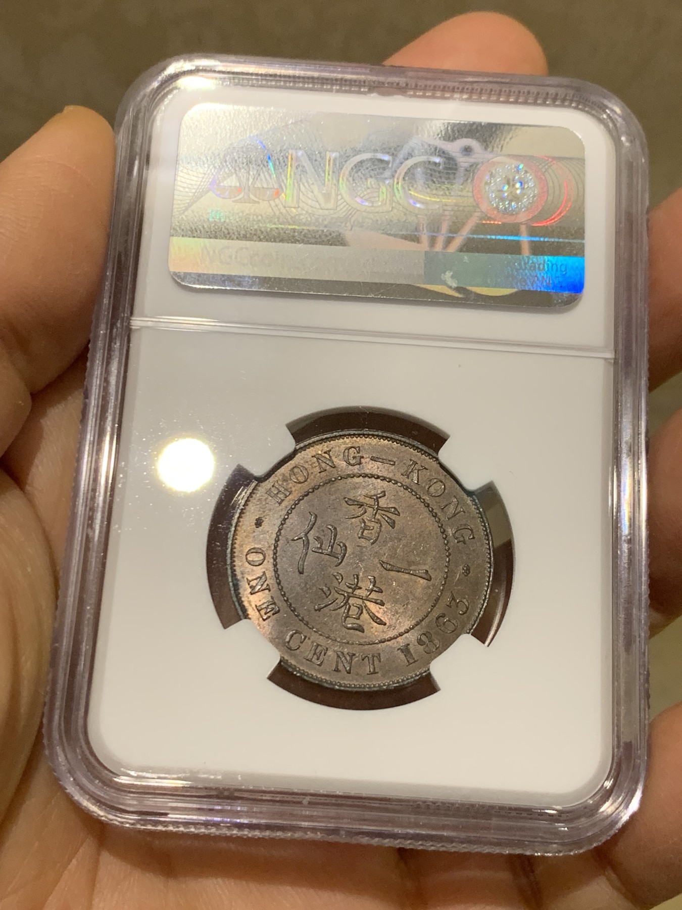 《竞宝斋》圣诞专辑  第一场  第227场 定制纪念章相赠 (全场顺丰包邮) NGC-MS63 香港1863年维多利亚女王香港一仙铜币。该品种流通币之首年，沿用了本土无神弗洛林的经典头像设计，背面是极具中国风味的文字排布，整币图案细腻文字工整，底板对光平滑，有一丝样币风范。以多点光源照射则光韵流畅盈满，辫子无常见弱打。巧克力色非常舒服，不输大多数64的状态，一步到位的东西。