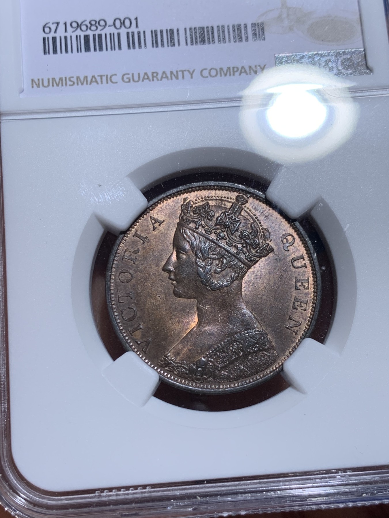 《竞宝斋》圣诞专辑  第一场  第227场 定制纪念章相赠 (全场顺丰包邮) NGC-MS63 香港1863年维多利亚女王香港一仙铜币。该品种流通币之首年，沿用了本土无神弗洛林的经典头像设计，背面是极具中国风味的文字排布，整币图案细腻文字工整，底板对光平滑，有一丝样币风范。以多点光源照射则光韵流畅盈满，辫子无常见弱打。巧克力色非常舒服，不输大多数64的状态，一步到位的东西。