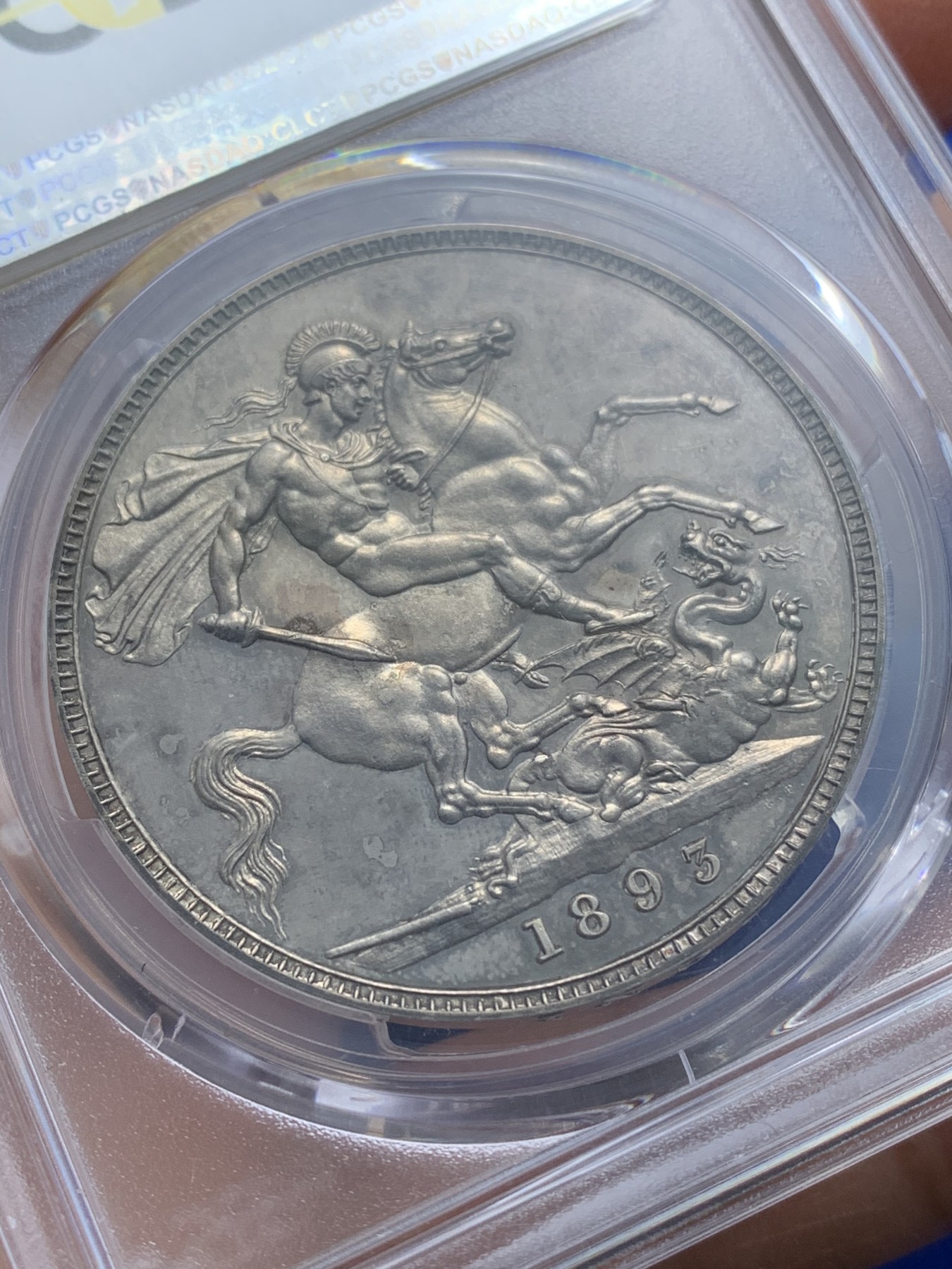 《竞宝斋》圣诞专辑  第二场  第228场 定制纪念章相赠 (全场顺丰包邮) PCGS PR63 英国维多利亚1893精制马剑克朗，最为经典的披沙造型，深色包浆。精制版，低估品种。