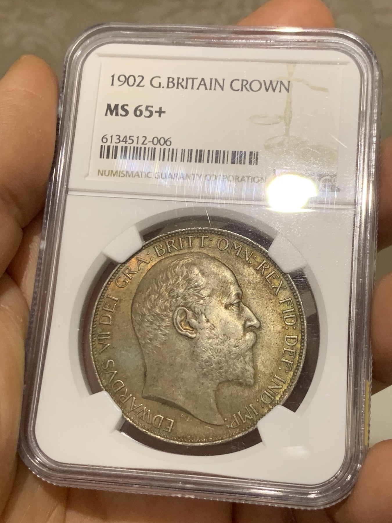 《竞宝斋》圣诞专辑  第二场  第228场 定制纪念章相赠 (全场顺丰包邮) NGC-MS65+ 英国1902年爱德华七世 克朗。双面都带有着原生的赤红的包浆。调查np数据库不难发现，该品种精制的高分数量接近普制的3倍，且该品种常见的苍蝇脚在此币上完全不可见，可惜打制稍弱让该币无法获评66分，但是其如水面波纹流转的转光依然在该品种内难见敌手。一年内的成交价：HA的pf-66/7800美元，苏尔曼pf-66落槌5000欧，英拍pf-65+落槌2800镑。普制高分已有数年未有在