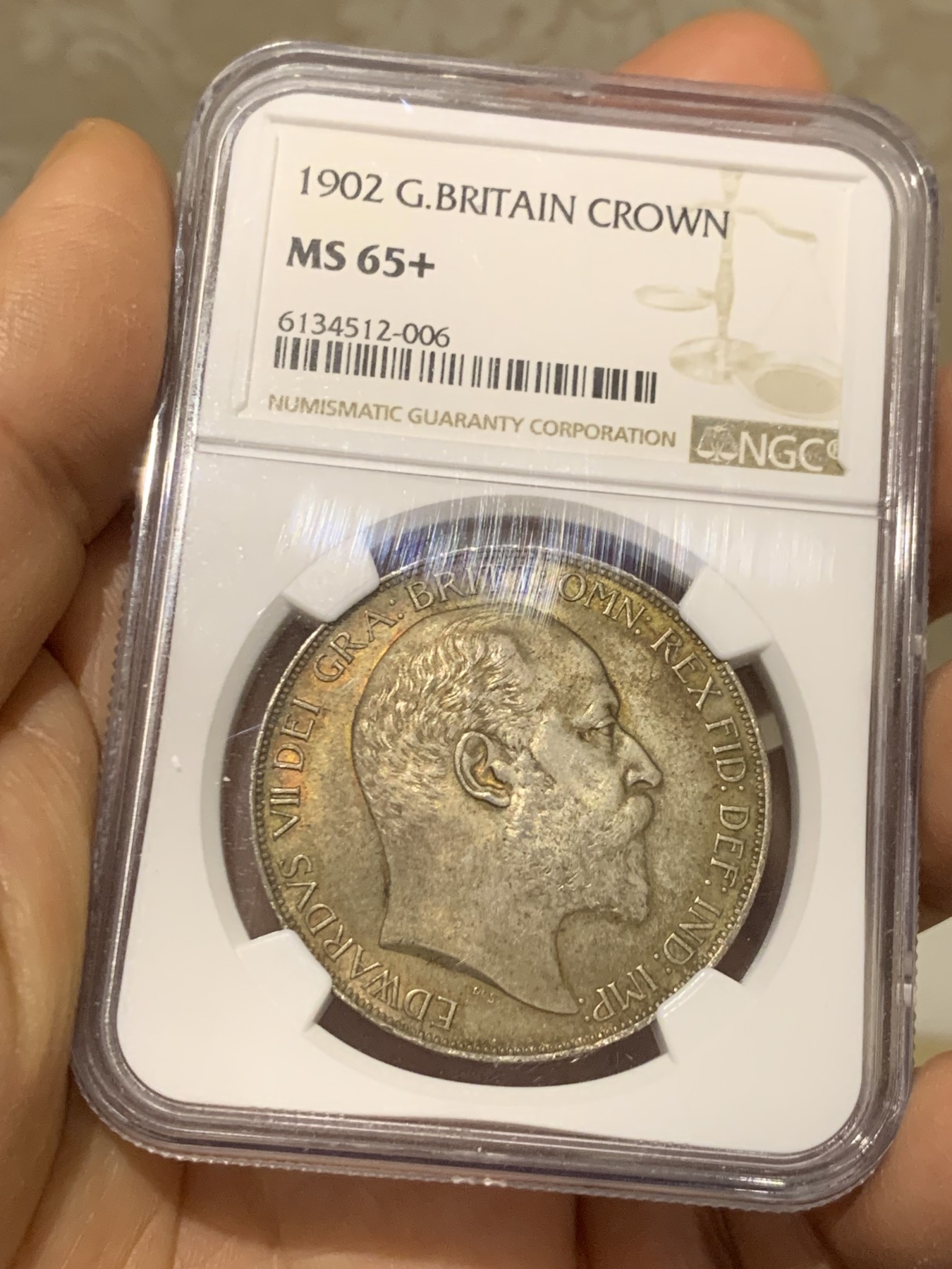 《竞宝斋》圣诞专辑  第二场  第228场 定制纪念章相赠 (全场顺丰包邮) NGC-MS65+ 英国1902年爱德华七世 克朗。双面都带有着原生的赤红的包浆。调查np数据库不难发现，该品种精制的高分数量接近普制的3倍，且该品种常见的苍蝇脚在此币上完全不可见，可惜打制稍弱让该币无法获评66分，但是其如水面波纹流转的转光依然在该品种内难见敌手。一年内的成交价：HA的pf-66/7800美元，苏尔曼pf-66落槌5000欧，英拍pf-65+落槌2800镑。普制高分已有数年未有在