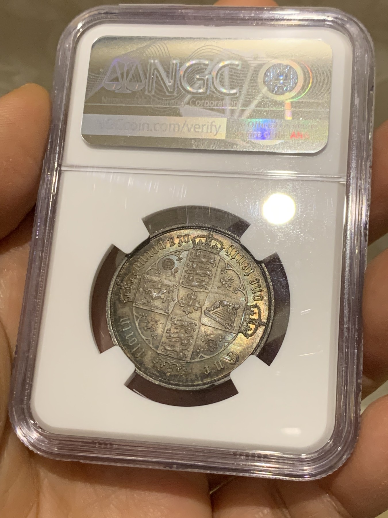 《竞宝斋》圣诞专辑  第二场  第228场 定制纪念章相赠 (全场顺丰包邮) NGC-MS63 英国1852年维多利亚女王哥特福林银币。正面包浆沉稳古气，但又能透出隐约的酒红光芒，背面是极其漂亮的五彩彩虹色过渡自然。这枚是整个系列的第一年，第一版女王面部线条和蔼柔美，值得入手。