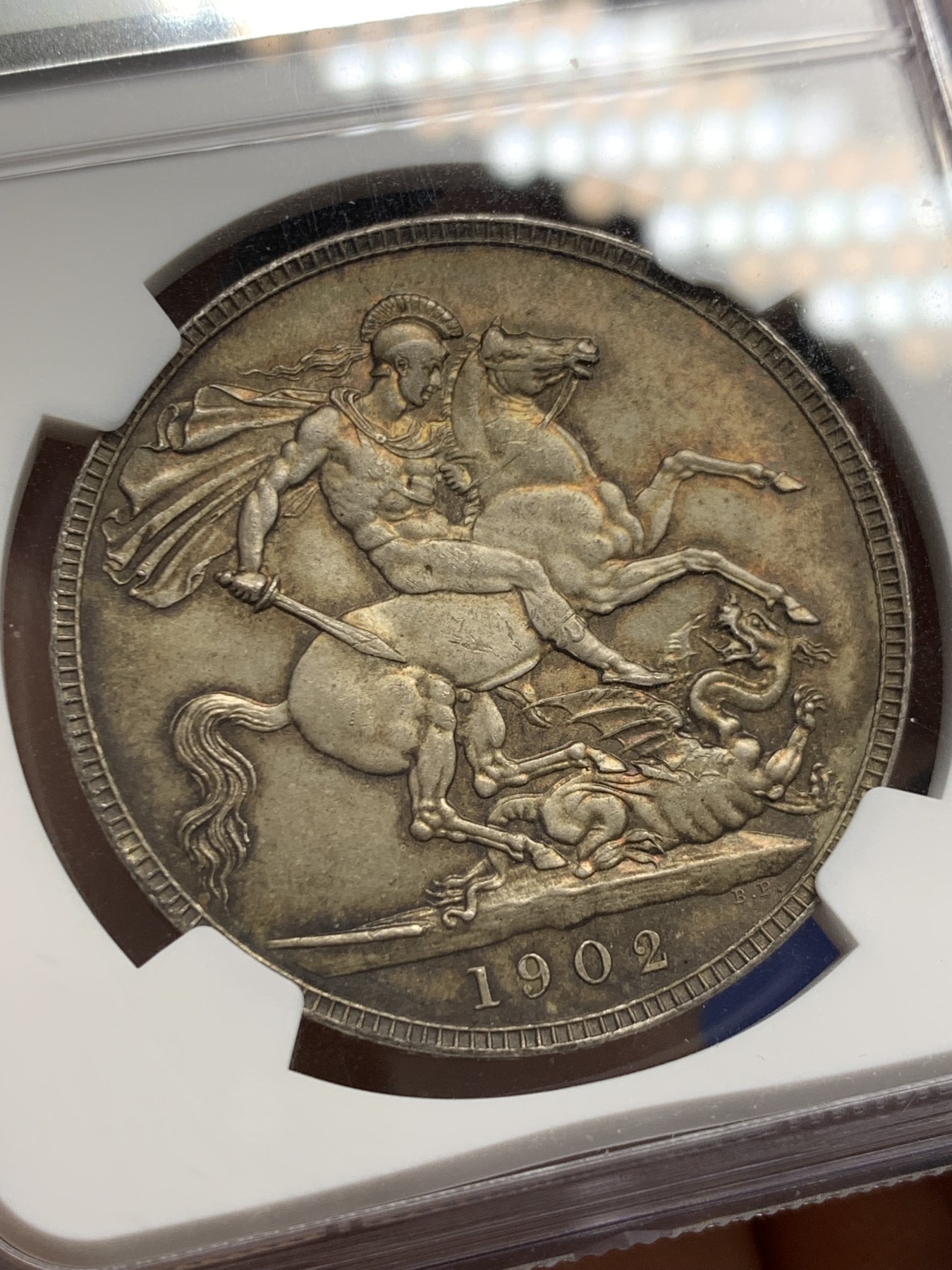 《竞宝斋》圣诞专辑  第二场  第228场 定制纪念章相赠 (全场顺丰包邮) NGC-MS65+ 英国1902年爱德华七世 克朗。双面都带有着原生的赤红的包浆。调查np数据库不难发现，该品种精制的高分数量接近普制的3倍，且该品种常见的苍蝇脚在此币上完全不可见，可惜打制稍弱让该币无法获评66分，但是其如水面波纹流转的转光依然在该品种内难见敌手。一年内的成交价：HA的pf-66/7800美元，苏尔曼pf-66落槌5000欧，英拍pf-65+落槌2800镑。普制高分已有数年未有在