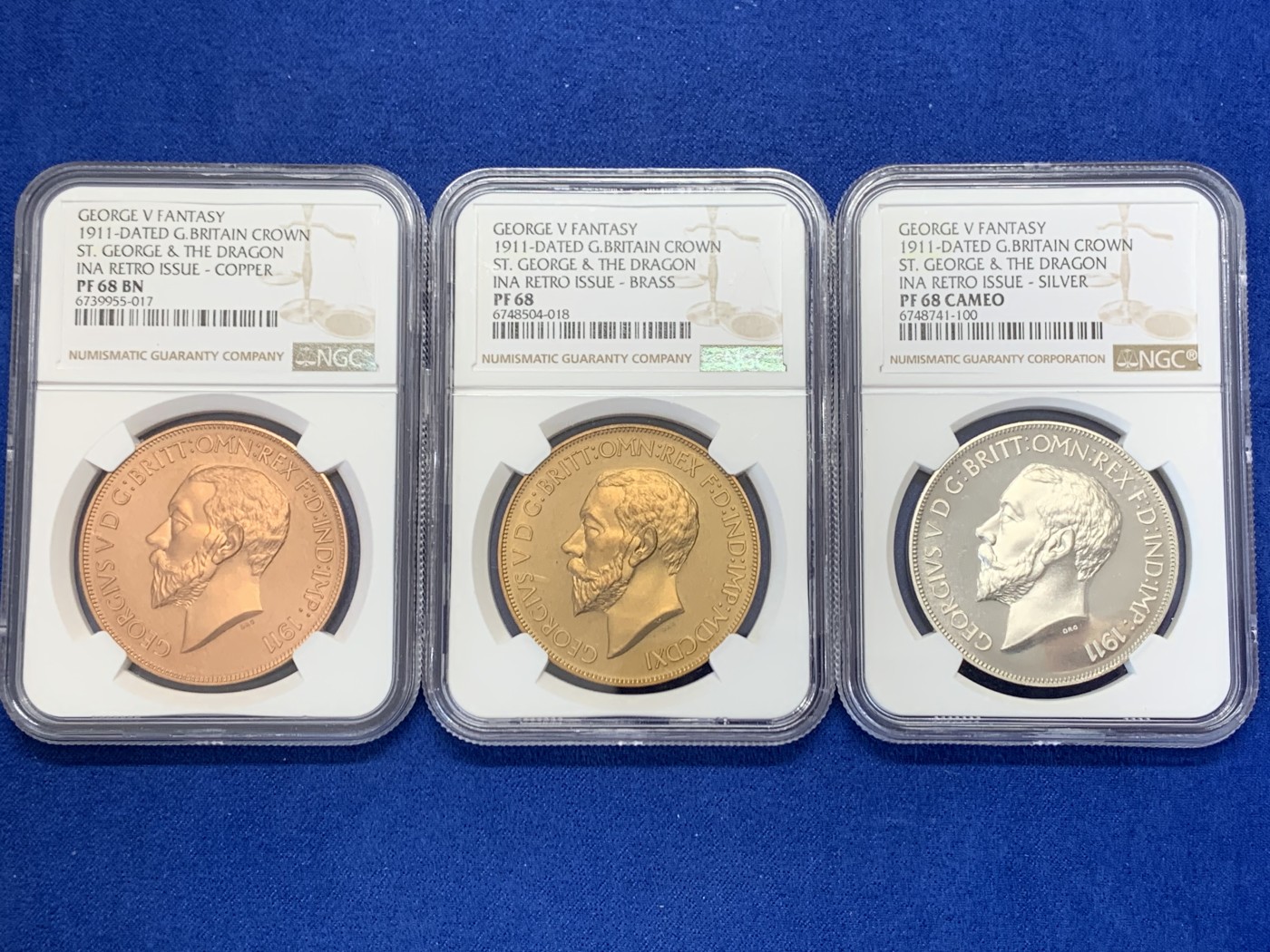 《竞宝斋》圣诞专辑  第二场  第228场 定制纪念章相赠 (全场顺丰包邮) 英国1911年乔治五世马剑屠龙珍惜币三枚套，NGC评级盒子，全部同分PF68，纯银，红铜，黄铜三个版本阵容豪华，著名的屠龙品种，颇受追捧，圣乔治屠龙设计的非常有特点，与以往的经典款式的严谨不同，更为粗犷简洁，线条明快，带有较为明显的欧洲新艺术风格，这种设计风格在2，30年代的法国币章上较为多见。