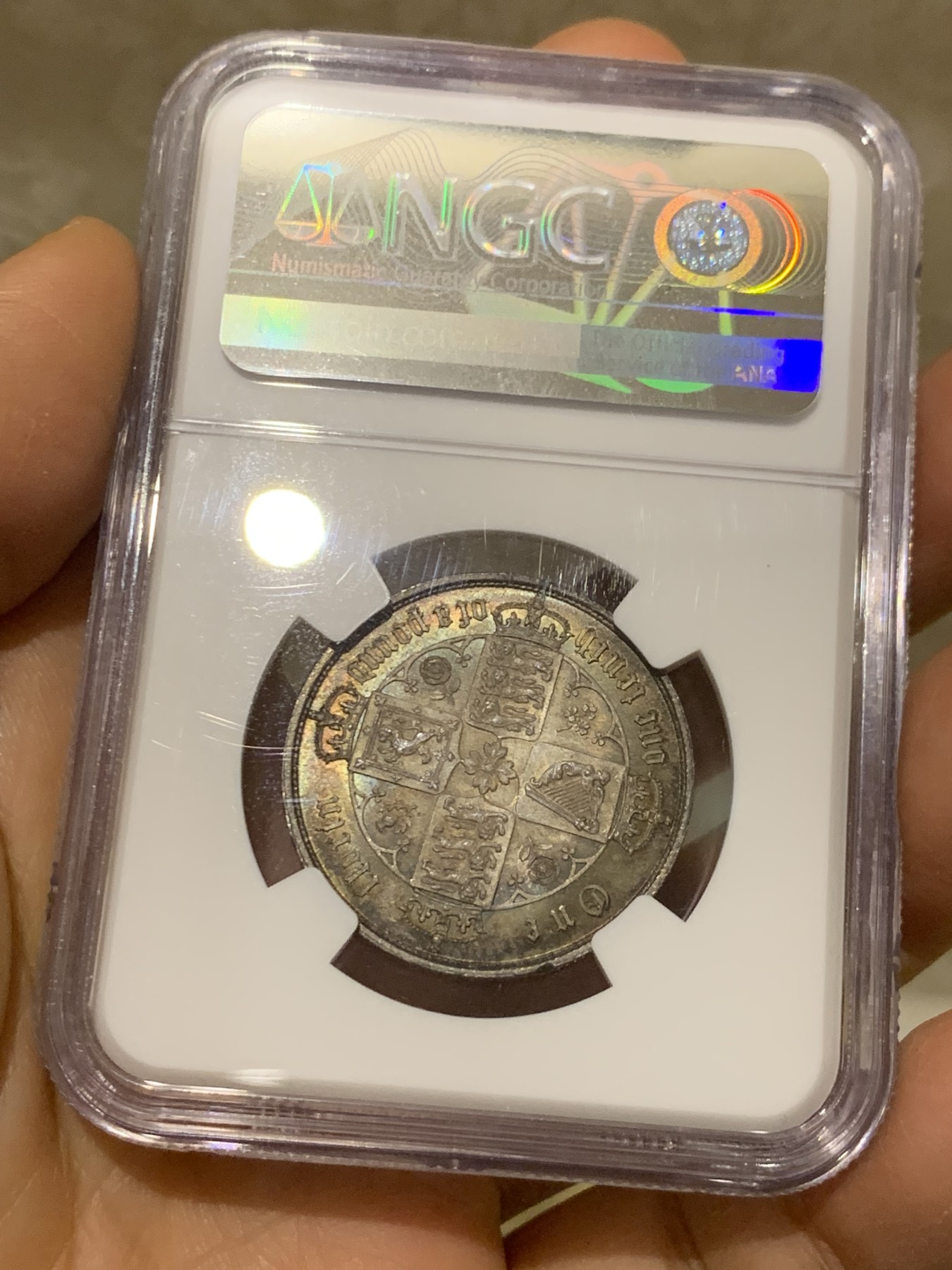 《竞宝斋》圣诞专辑  第二场  第228场 定制纪念章相赠 (全场顺丰包邮) NGC-MS63 英国1852年维多利亚女王哥特福林银币。正面包浆沉稳古气，但又能透出隐约的酒红光芒，背面是极其漂亮的五彩彩虹色过渡自然。这枚是整个系列的第一年，第一版女王面部线条和蔼柔美，值得入手。