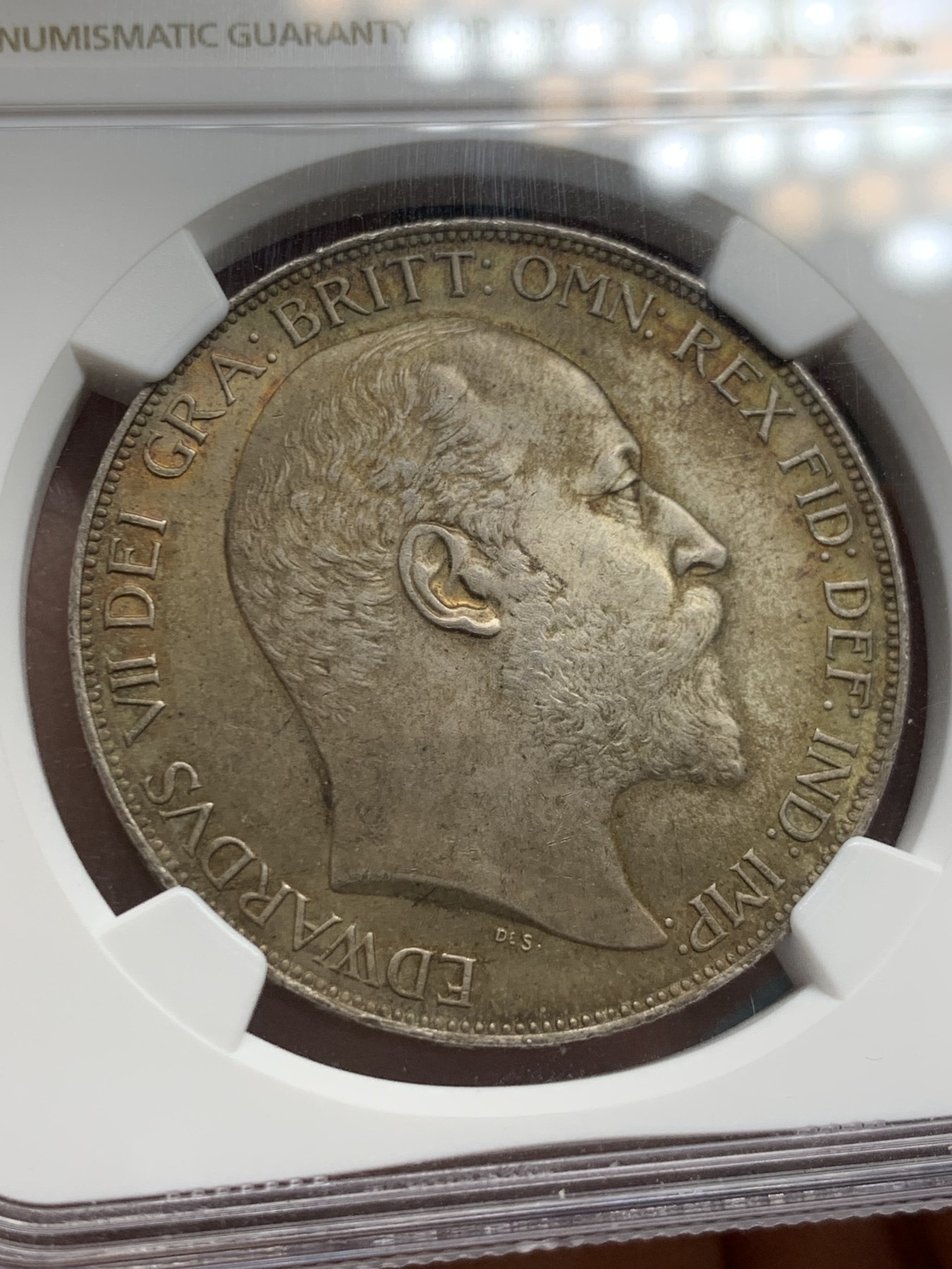 《竞宝斋》圣诞专辑  第二场  第228场 定制纪念章相赠 (全场顺丰包邮) NGC-MS65+ 英国1902年爱德华七世 克朗。双面都带有着原生的赤红的包浆。调查np数据库不难发现，该品种精制的高分数量接近普制的3倍，且该品种常见的苍蝇脚在此币上完全不可见，可惜打制稍弱让该币无法获评66分，但是其如水面波纹流转的转光依然在该品种内难见敌手。一年内的成交价：HA的pf-66/7800美元，苏尔曼pf-66落槌5000欧，英拍pf-65+落槌2800镑。普制高分已有数年未有在