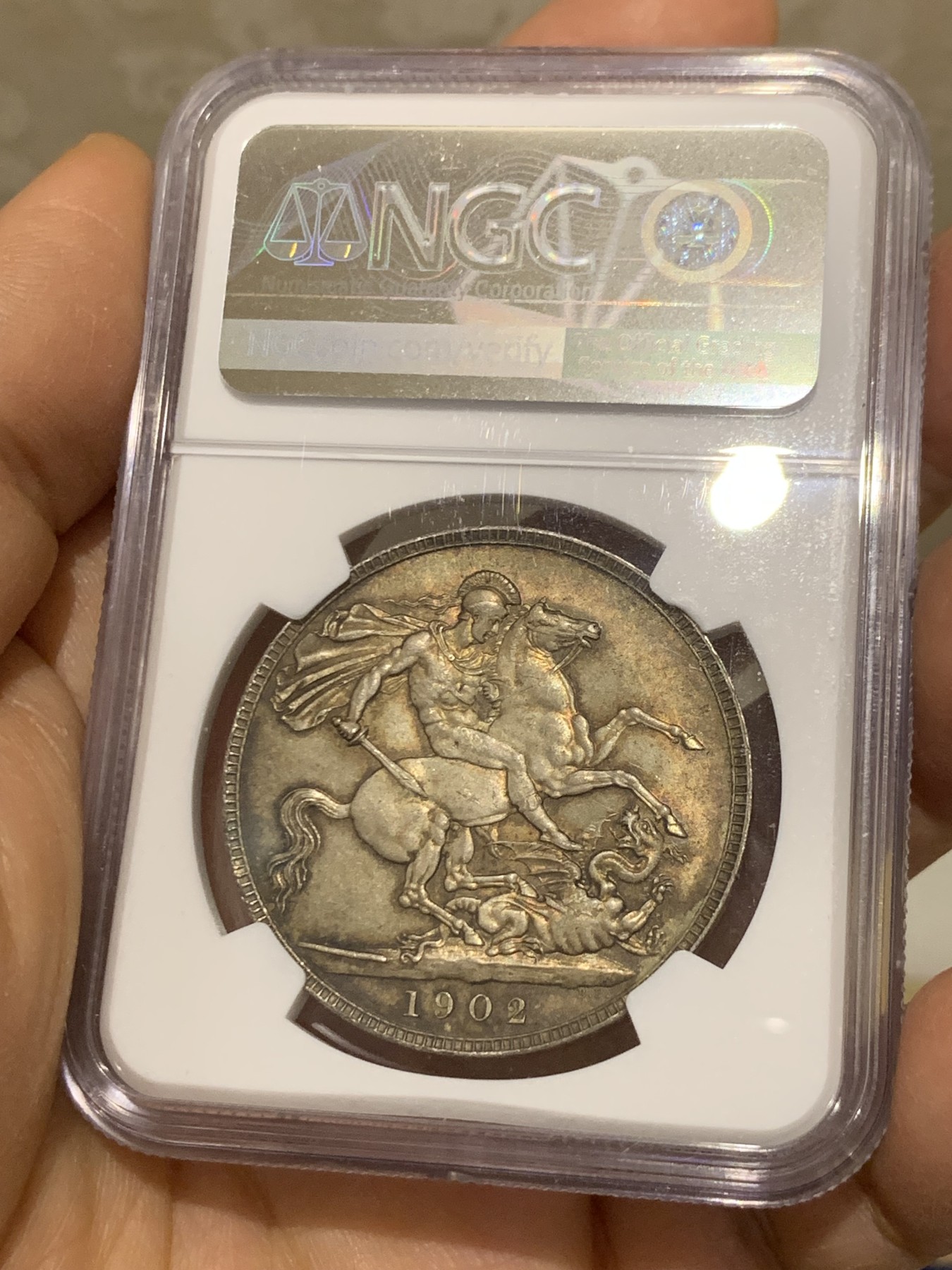 《竞宝斋》圣诞专辑  第二场  第228场 定制纪念章相赠 (全场顺丰包邮) NGC-MS65+ 英国1902年爱德华七世 克朗。双面都带有着原生的赤红的包浆。调查np数据库不难发现，该品种精制的高分数量接近普制的3倍，且该品种常见的苍蝇脚在此币上完全不可见，可惜打制稍弱让该币无法获评66分，但是其如水面波纹流转的转光依然在该品种内难见敌手。一年内的成交价：HA的pf-66/7800美元，苏尔曼pf-66落槌5000欧，英拍pf-65+落槌2800镑。普制高分已有数年未有在