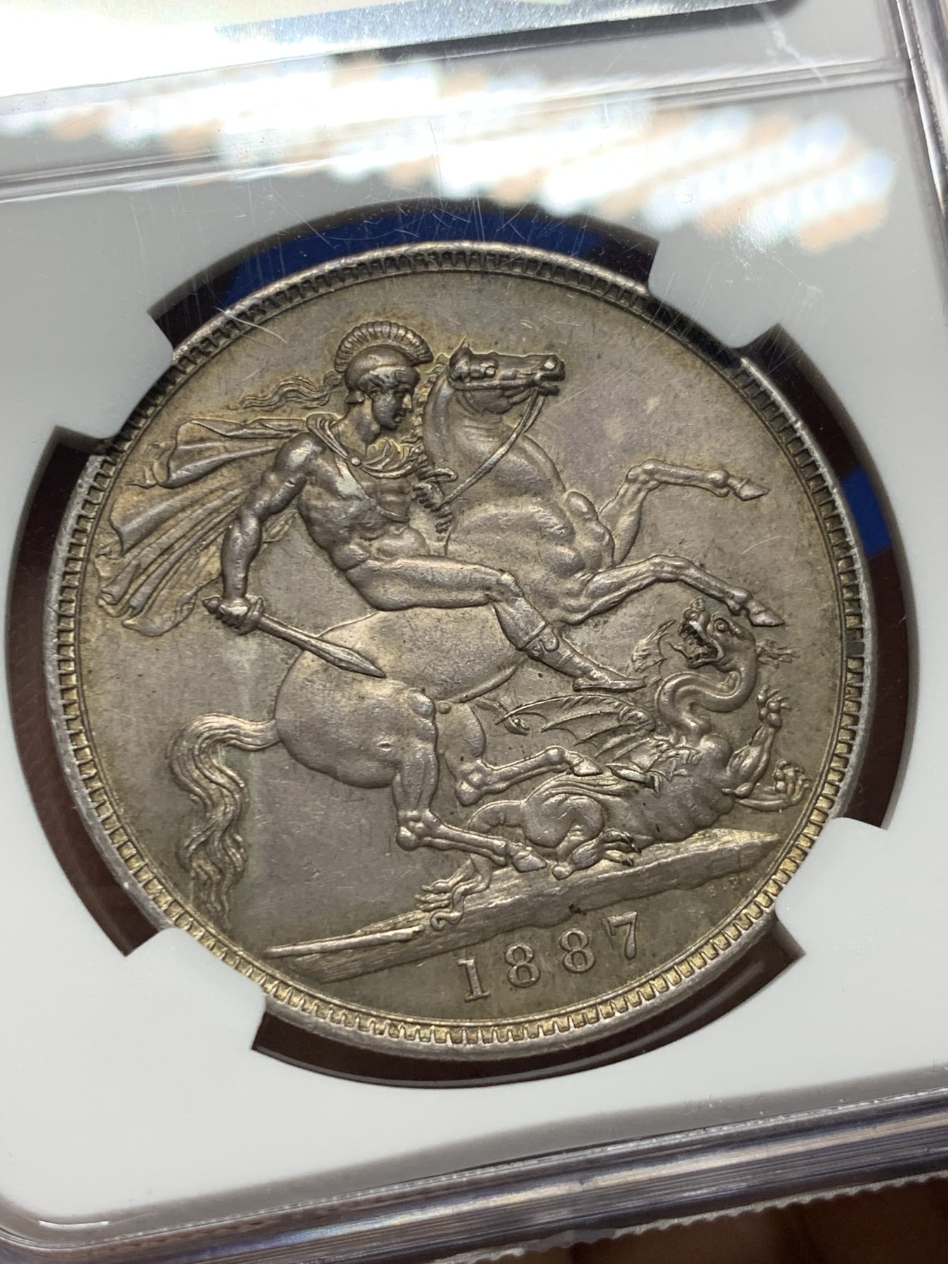 《竞宝斋》圣诞专辑  第二场  第228场 定制纪念章相赠 (全场顺丰包邮) NGC-AU58 英国 1887年 维多利亚马剑1克朗银币。原味包浆，细节佳全深打，性价比之选。