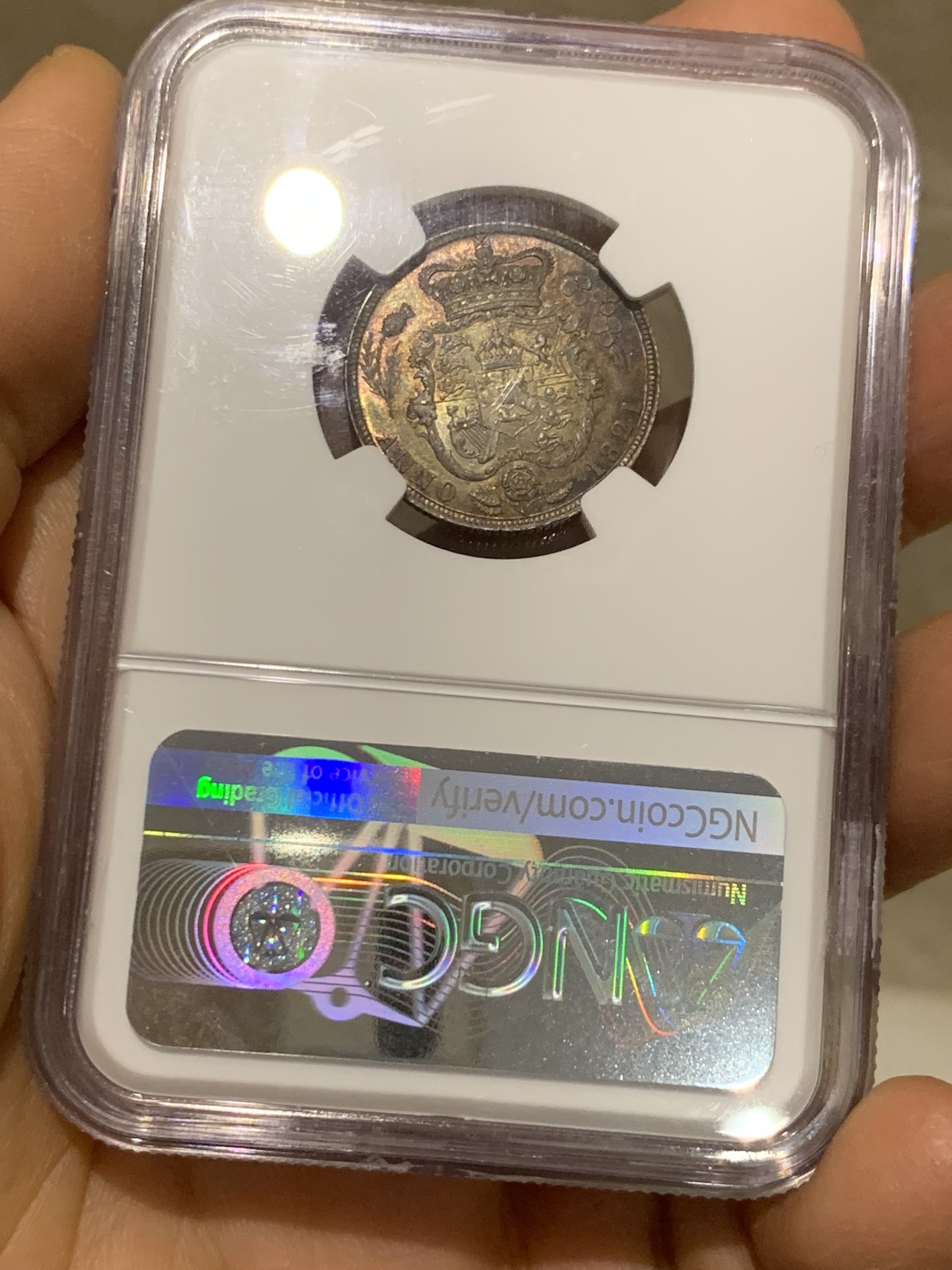 《竞宝斋》圣诞专辑  第二场  第228场 定制纪念章相赠 (全场顺丰包邮) NGC-MS66 英国1821年乔治四世1先令银币。币面环绕暖色系包浆，橘黄，红酒色，梅红，紫罗兰循序渐进。双面经典，正面头像来自皮斯特鲁奇；背面三花图案来自简·帕皮提斯特·梅林，签名隐藏在内齿。三叶草上暗记wwp为mint master的简拼。美国知名币商66+售价1850美金。