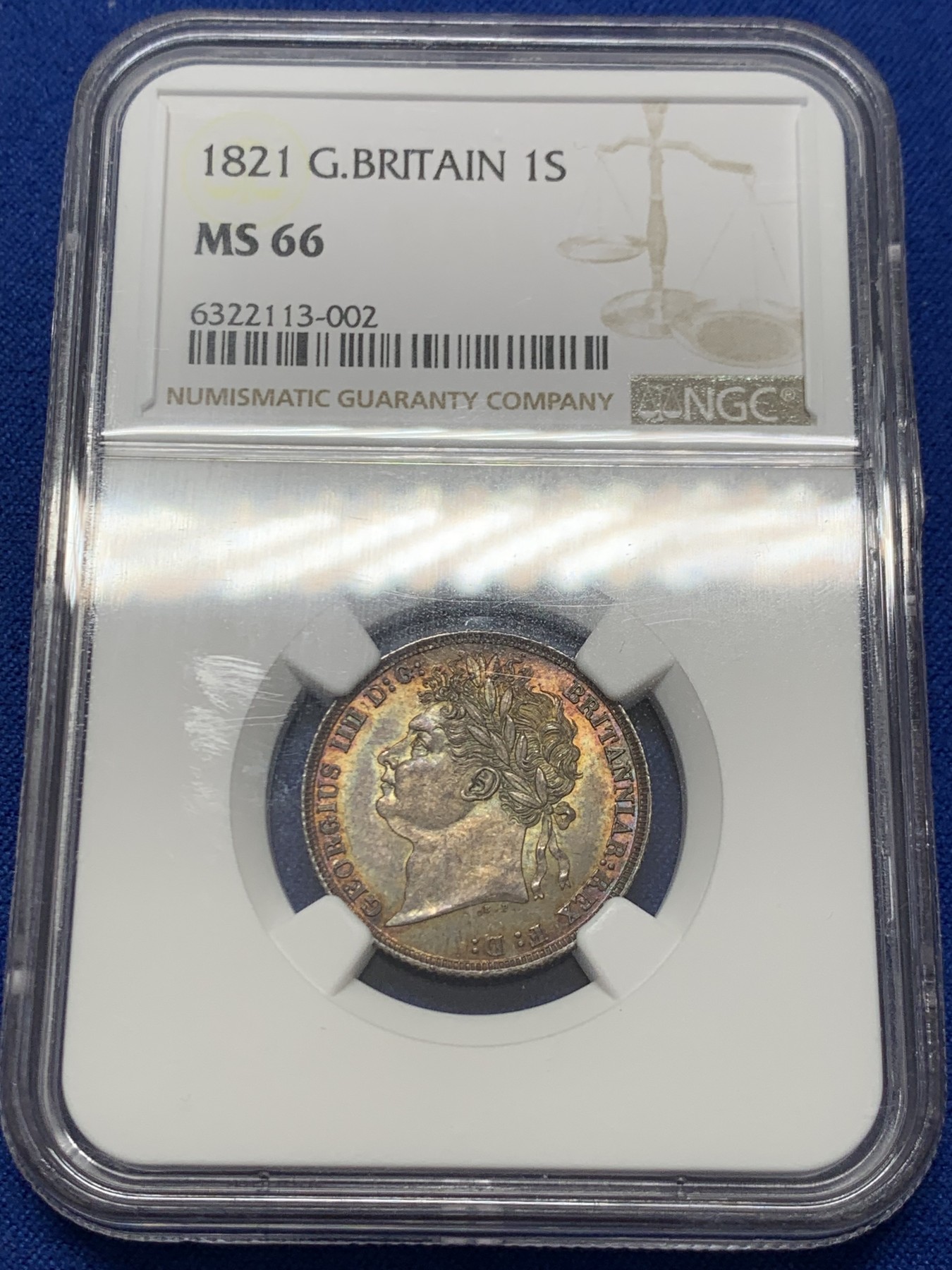 《竞宝斋》圣诞专辑  第二场  第228场 定制纪念章相赠 (全场顺丰包邮) NGC-MS66 英国1821年乔治四世1先令银币。币面环绕暖色系包浆，橘黄，红酒色，梅红，紫罗兰循序渐进。双面经典，正面头像来自皮斯特鲁奇；背面三花图案来自简·帕皮提斯特·梅林，签名隐藏在内齿。三叶草上暗记wwp为mint master的简拼。美国知名币商66+售价1850美金。