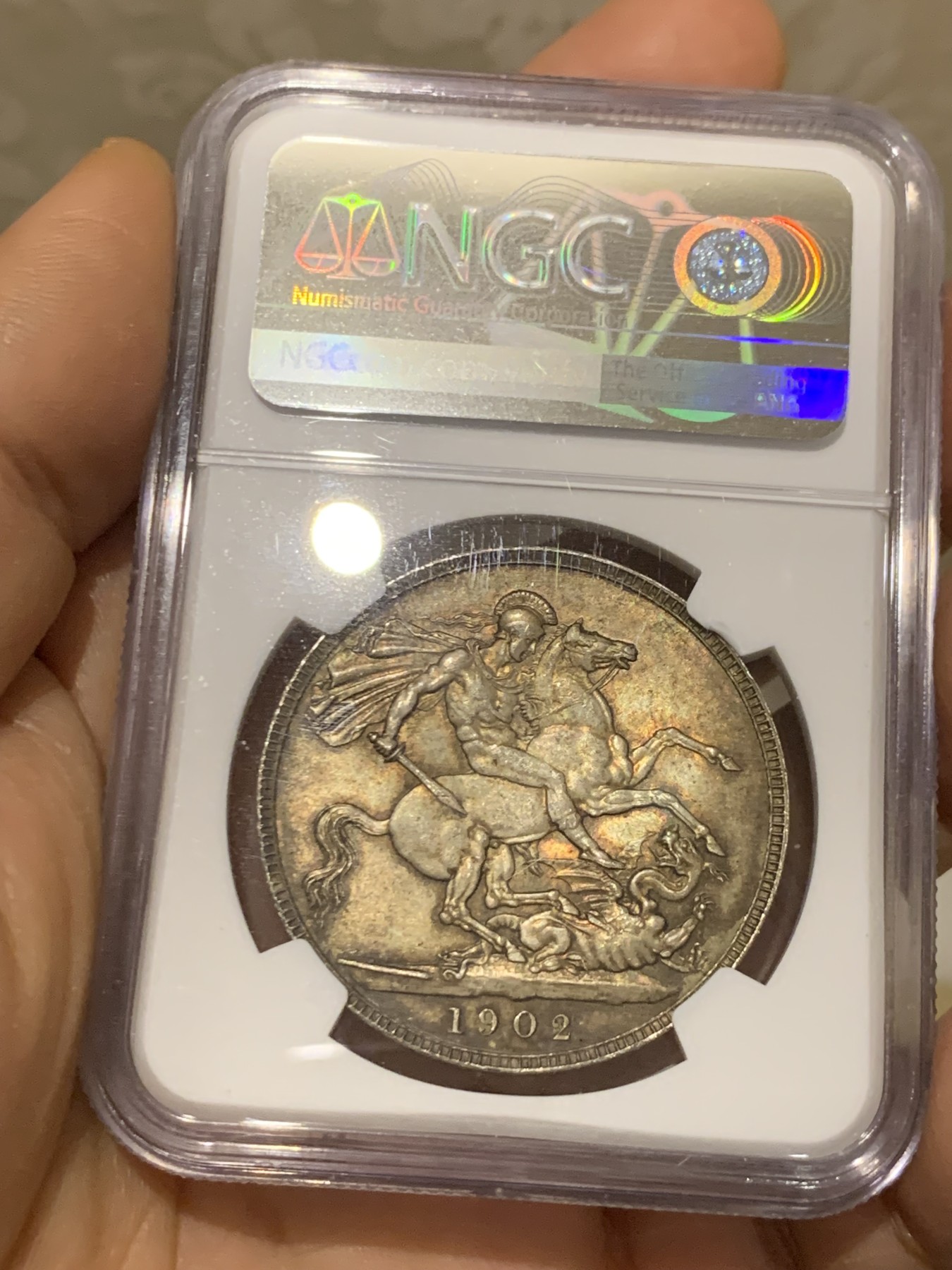 《竞宝斋》圣诞专辑  第二场  第228场 定制纪念章相赠 (全场顺丰包邮) NGC-MS65+ 英国1902年爱德华七世 克朗。双面都带有着原生的赤红的包浆。调查np数据库不难发现，该品种精制的高分数量接近普制的3倍，且该品种常见的苍蝇脚在此币上完全不可见，可惜打制稍弱让该币无法获评66分，但是其如水面波纹流转的转光依然在该品种内难见敌手。一年内的成交价：HA的pf-66/7800美元，苏尔曼pf-66落槌5000欧，英拍pf-65+落槌2800镑。普制高分已有数年未有在