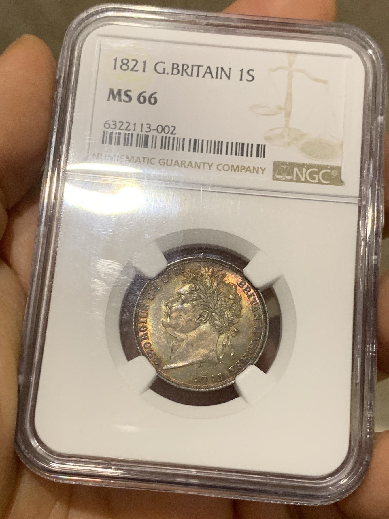 《竞宝斋》圣诞专辑  第二场  第228场 定制纪念章相赠 (全场顺丰包邮) NGC-MS66 英国1821年乔治四世1先令银币。币面环绕暖色系包浆，橘黄，红酒色，梅红，紫罗兰循序渐进。双面经典，正面头像来自皮斯特鲁奇；背面三花图案来自简·帕皮提斯特·梅林，签名隐藏在内齿。三叶草上暗记wwp为mint master的简拼。美国知名币商66+售价1850美金。