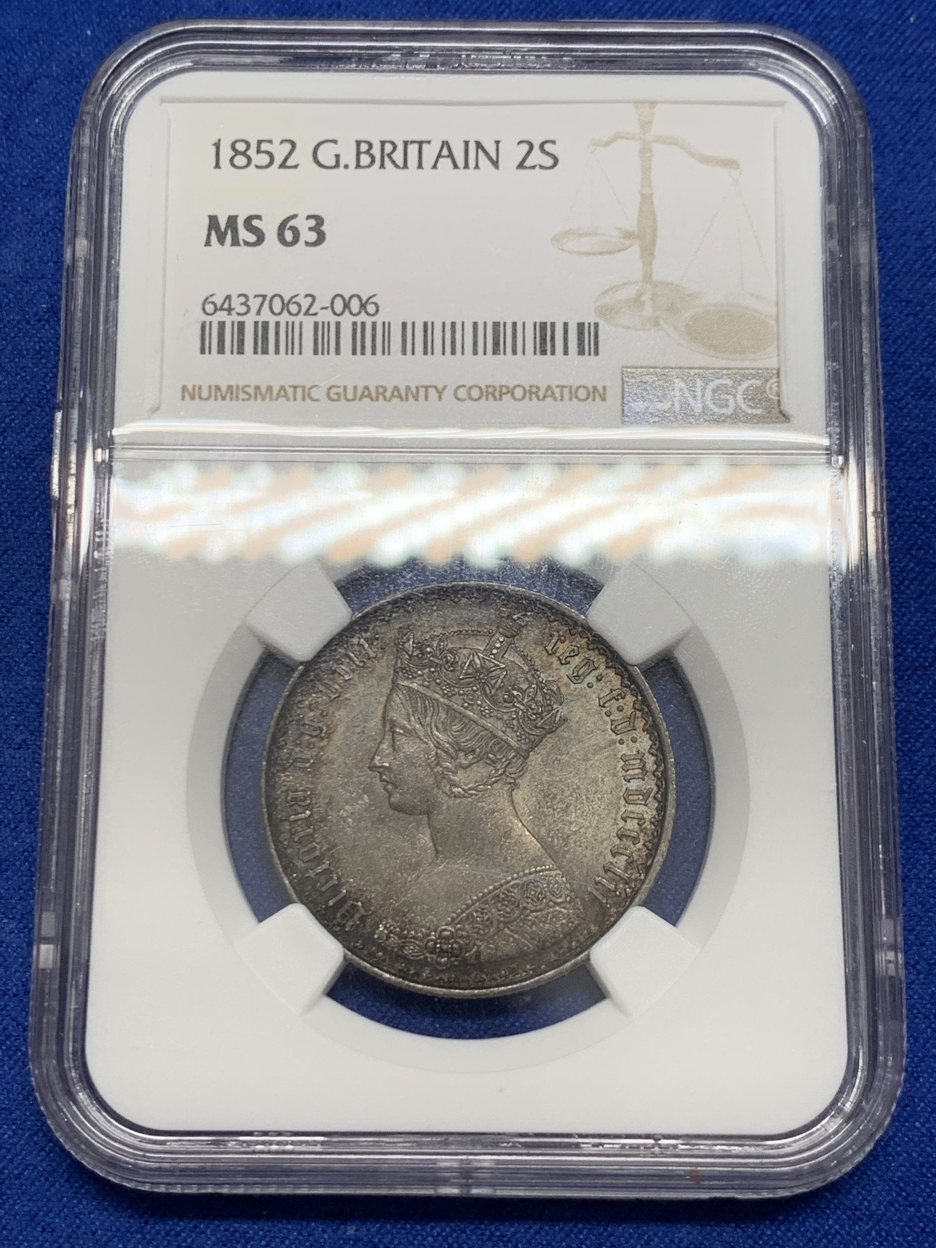 《竞宝斋》圣诞专辑  第二场  第228场 定制纪念章相赠 (全场顺丰包邮) NGC-MS63 英国1852年维多利亚女王哥特福林银币。正面包浆沉稳古气，但又能透出隐约的酒红光芒，背面是极其漂亮的五彩彩虹色过渡自然。这枚是整个系列的第一年，第一版女王面部线条和蔼柔美，值得入手。