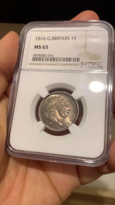 《竞宝斋》圣诞专辑  第二场  第228场 定制纪念章相赠 (全场顺丰包邮) NGC-MS65 英国1816年乔治三世 牛头1先令 银币。来自皮斯特鲁奇的经典设计，状态很舒服，分数够玩了。